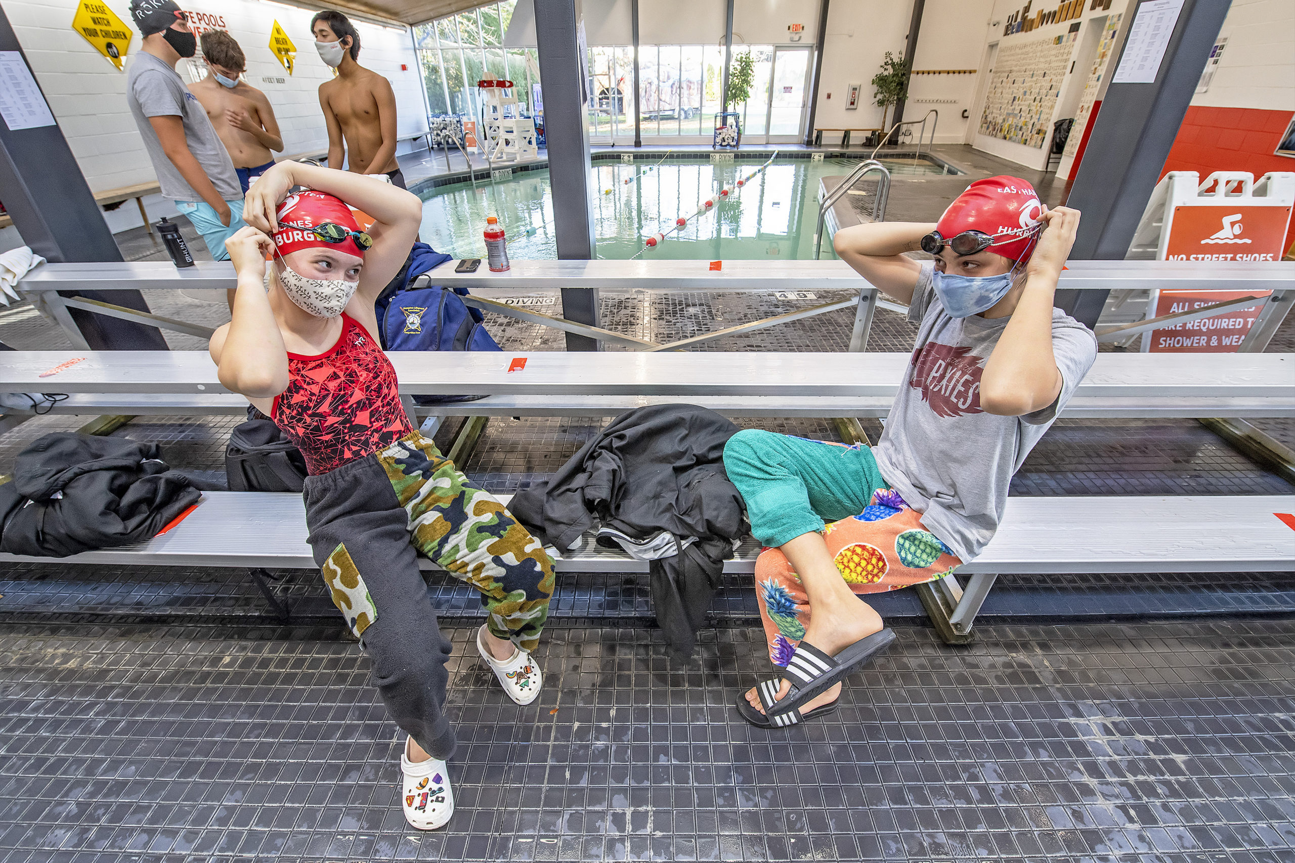 Hurricanes swimmers Sarah Stanburg and Fray Wood take COVID precautions as they prepare to compete during the swim meet between the East Hampton Hurricanes travel team and the Bluefish from the Huntington YMCA at the East Hampton YMCA RECenter on Saturday afternoon.         MICHAEL HELLER