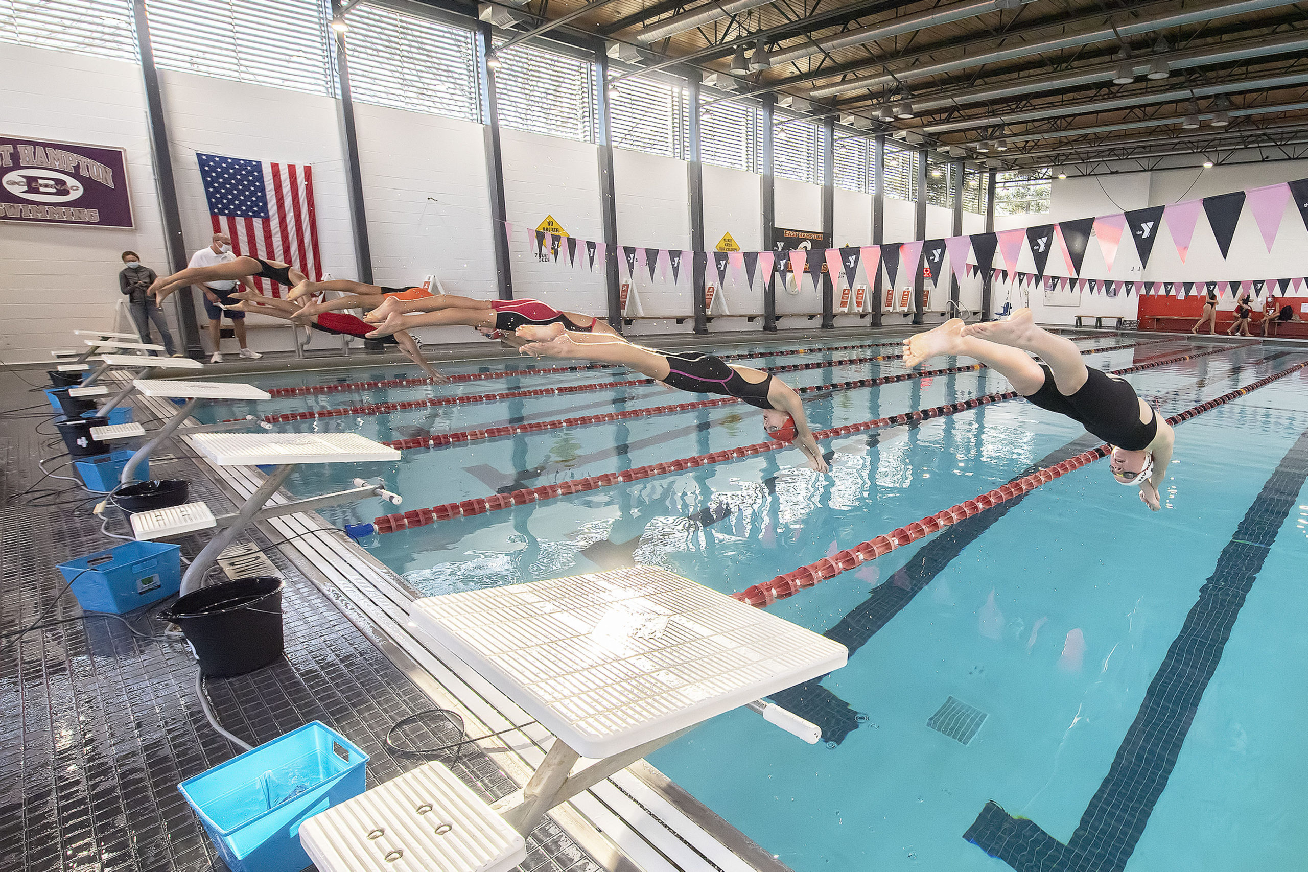 Competitors dive in unison during the swim meet between the East Hampton Hurricanes travel team and the Bluefish from the Huntington YMCA at the East Hampton YMCA RECenter on Saturday afternoon.  MICHAEL HELLER