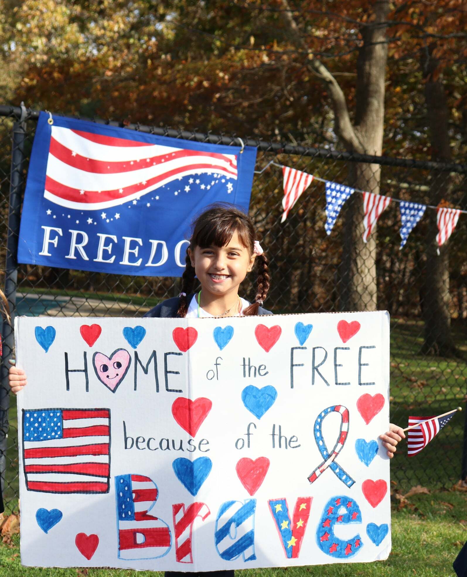 Second-grade student, Gigi Trimarco, celebrates the veterans during Raynor Country Day School's annual Celebration.
