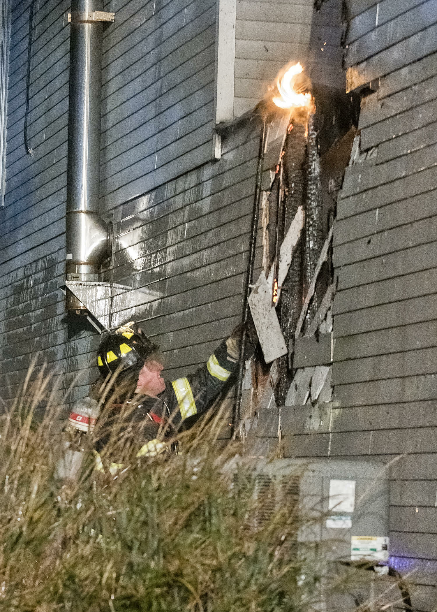 Tom Glover opens up a wall to attack the blaze. COURTESY WESTHAMPTON BEACH FIRE DEPARTMENT