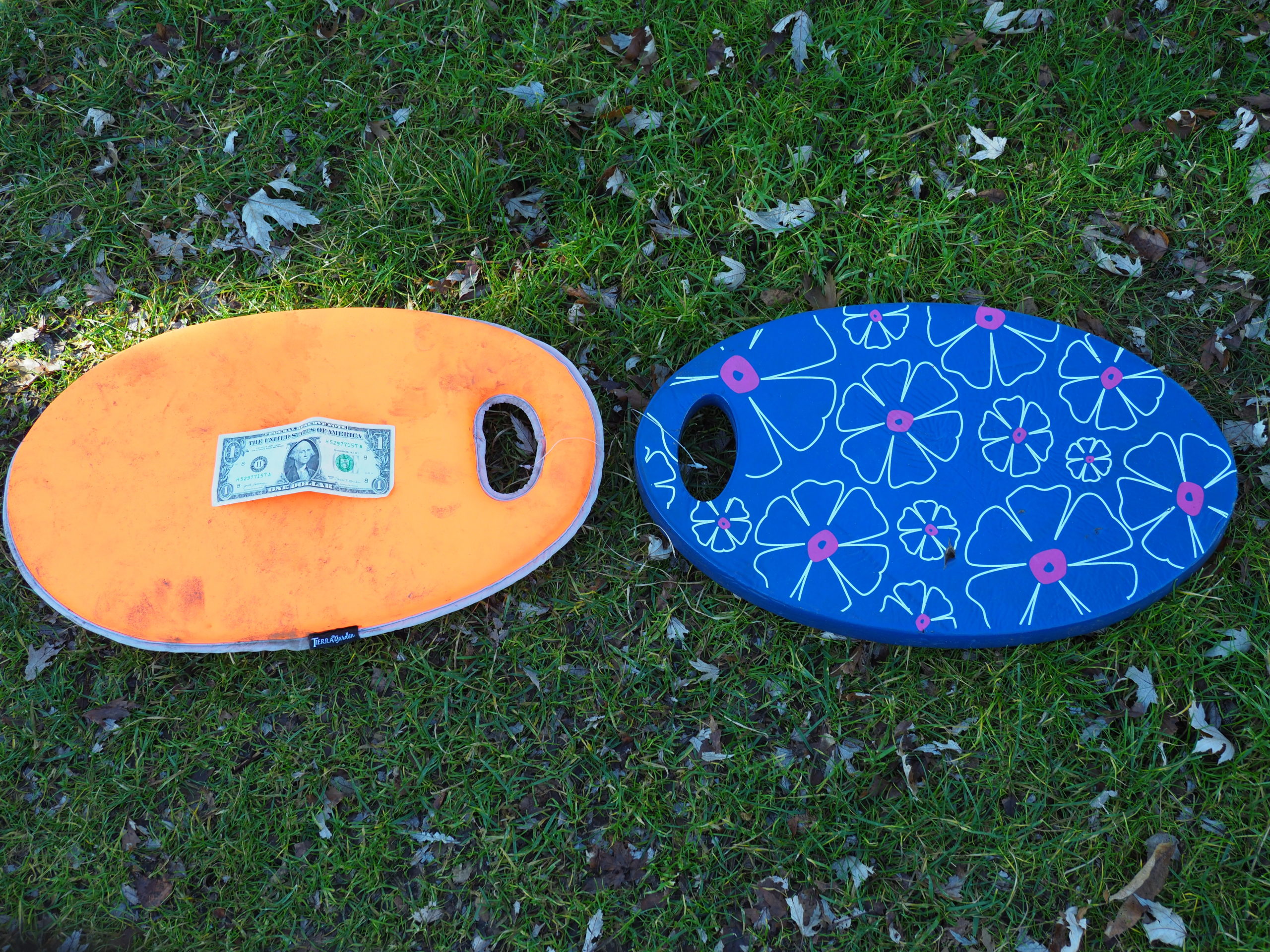 Two different density kneeling pads. The one on the left (dollar bill is for size reference) is soft and spongy and would work on sandy soils and soft areas. The pad on the right is a medium firm one and well suited for all uses and knees.