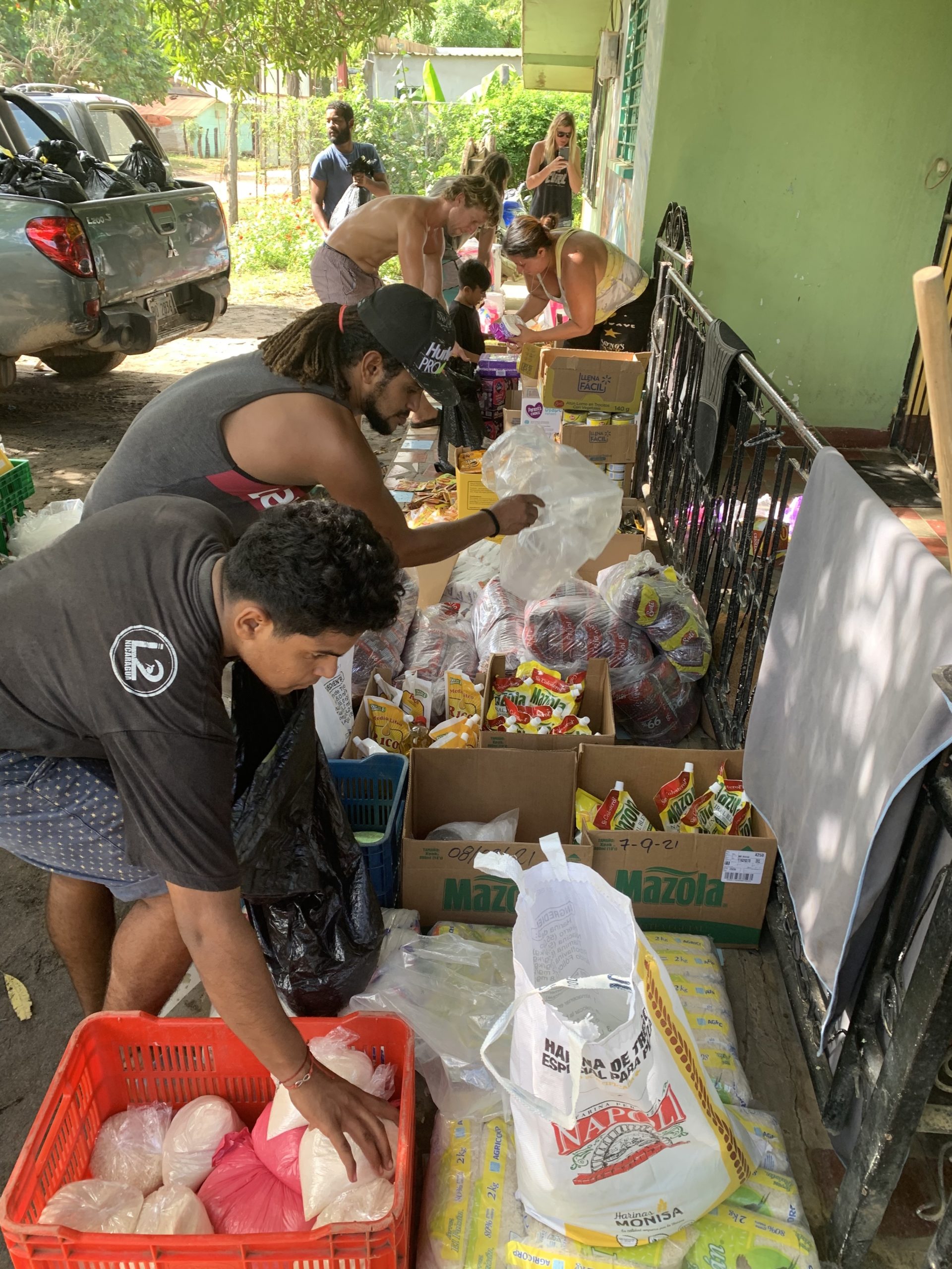 Volunteers from different communities help divide and repackage donations before distributing them to neighborhoods destroyed by hurricane flooding and high winds in Nicaragua.