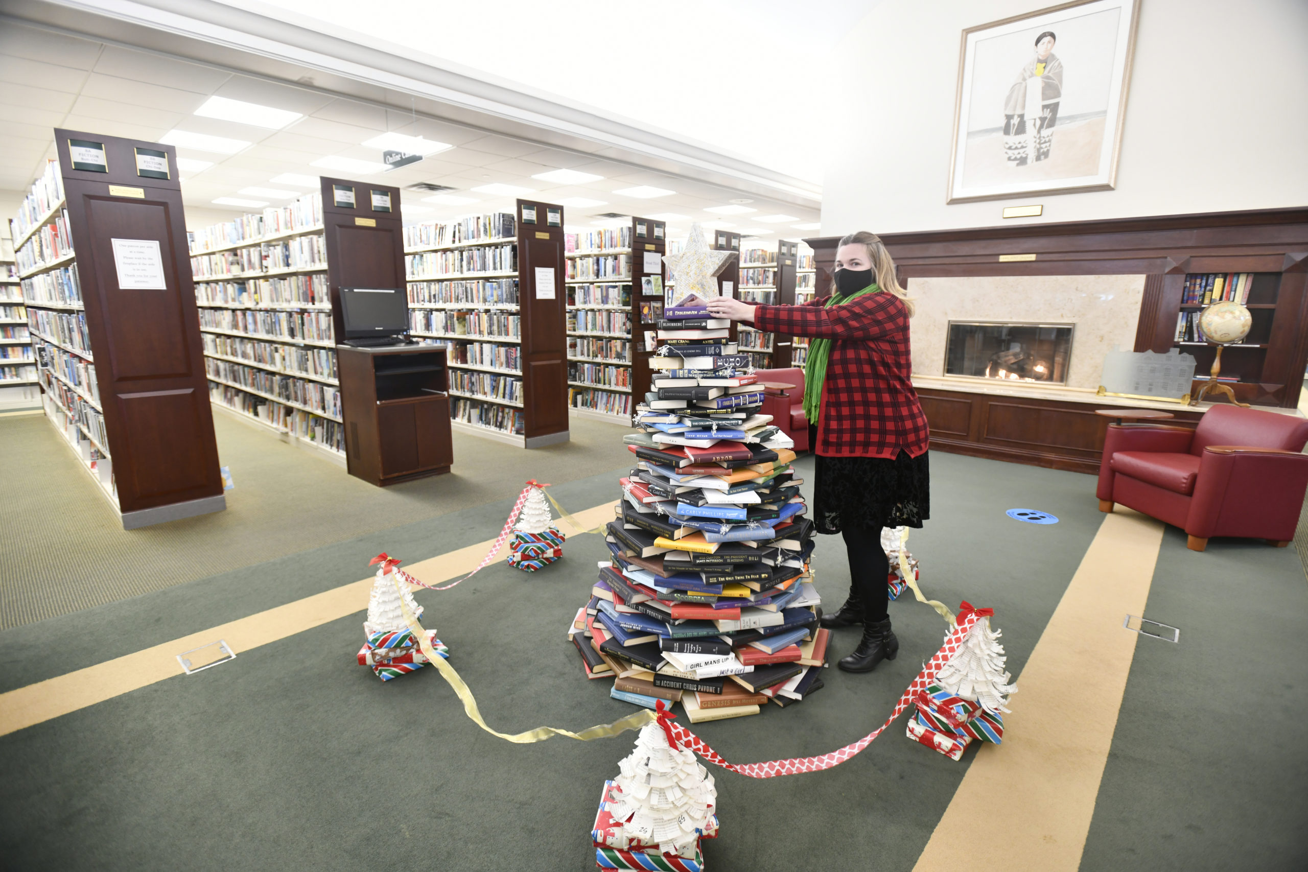 Casey Fehn, pictured, Head of Teen Services at the Rogers Memorial Library and Reference Librarian Sara Fiore recently created a holiday display out of old, used books at the library. DANA SHAW