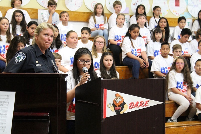 Officer Kim Notel leading a D.A.R.E. graduation at Springs School