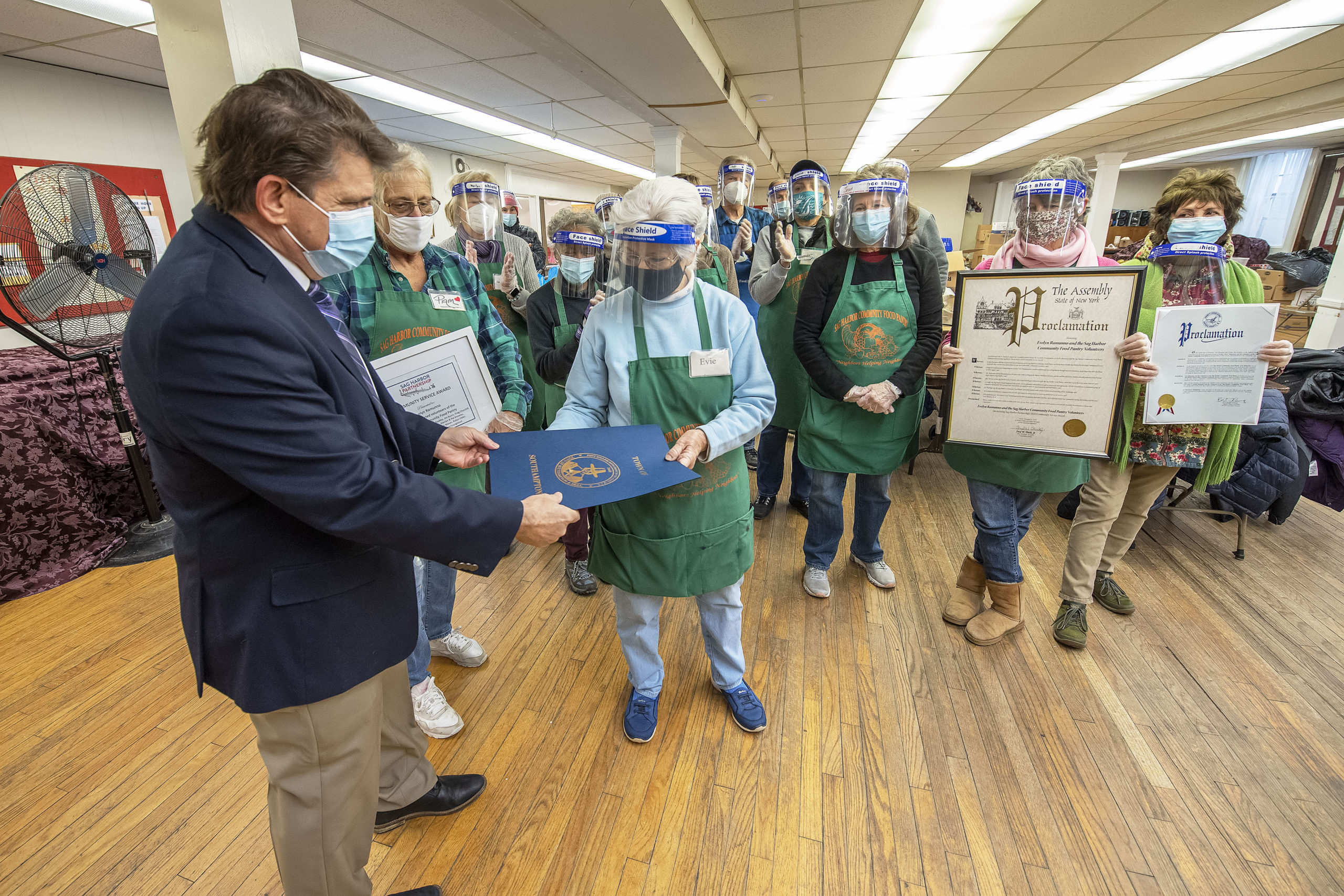 Southampton Town Councilman Tommy John Schiavoni presents members of the Sag Harbor Community Food Pantry with a town proclamation. 