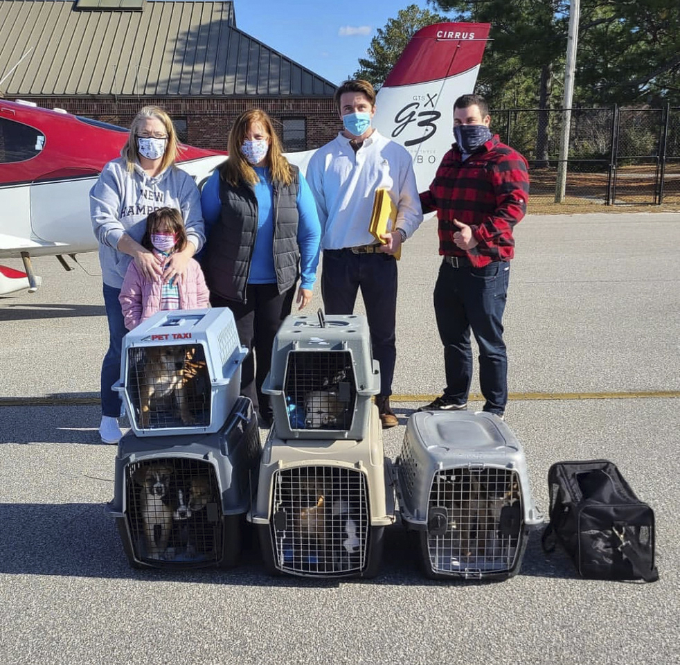 Volunteers from Fostering Foster Animal Rescue at the airport in Camden, South Carolina, with pilots Charles Canavan and Brian LaBelle (right), the owner of the airplane that carried 15 puppies to East Hampton Airport fort delivery to ARF. COURTESY CHARLES CANAVAN