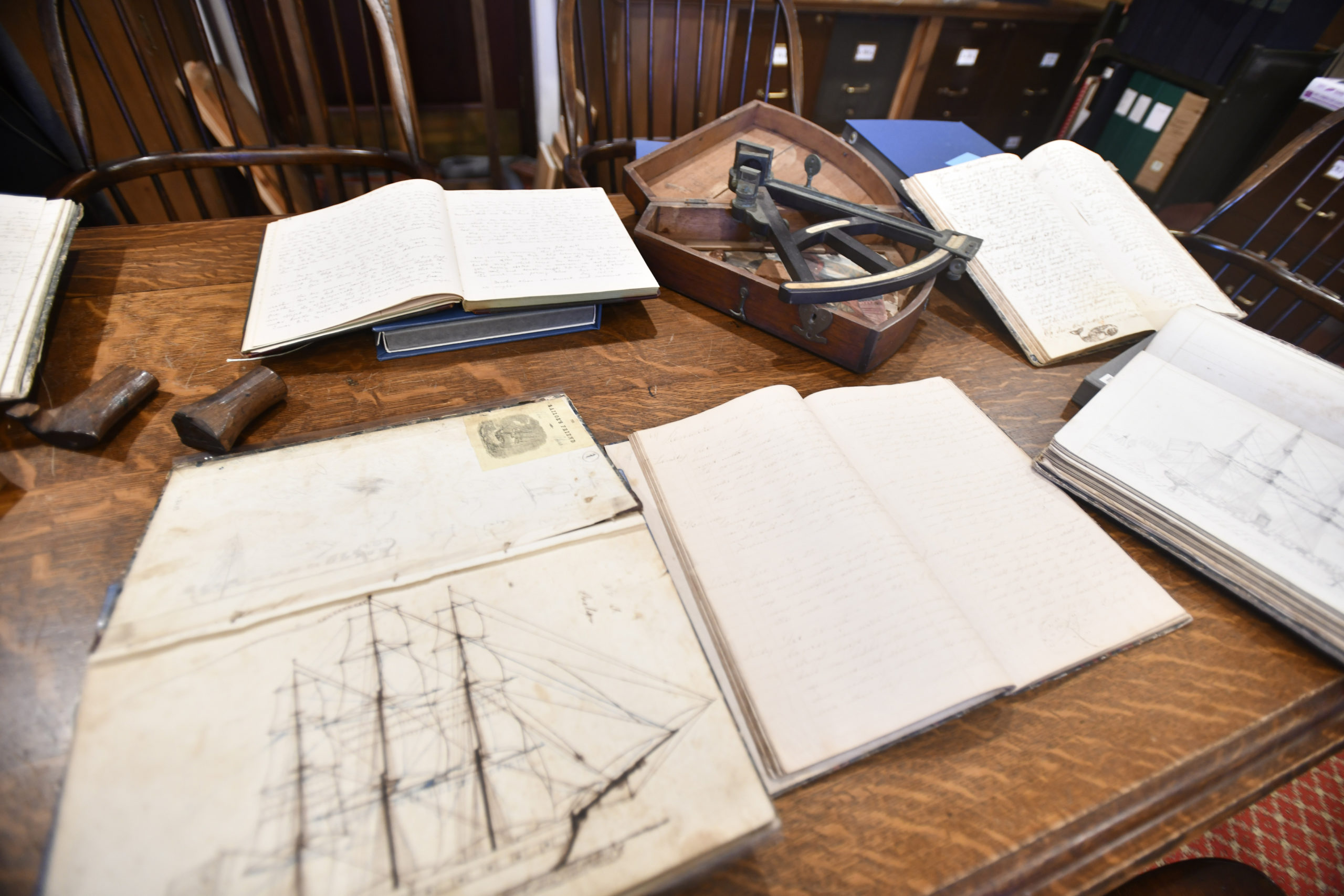 Some of the whaling logs and items from the East Hampton Library's Long Island Collection, including a sextant and carved whale stamps.  DANA SHAW