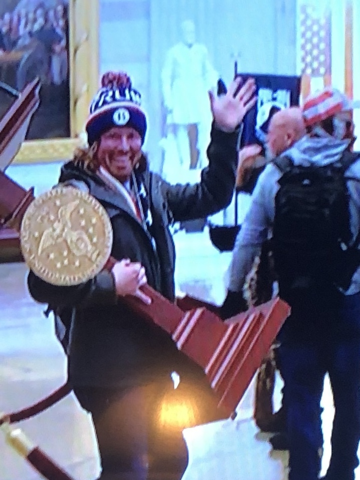 One of the looters with an item taken from the Capitol Building, shown on television Wednesday.