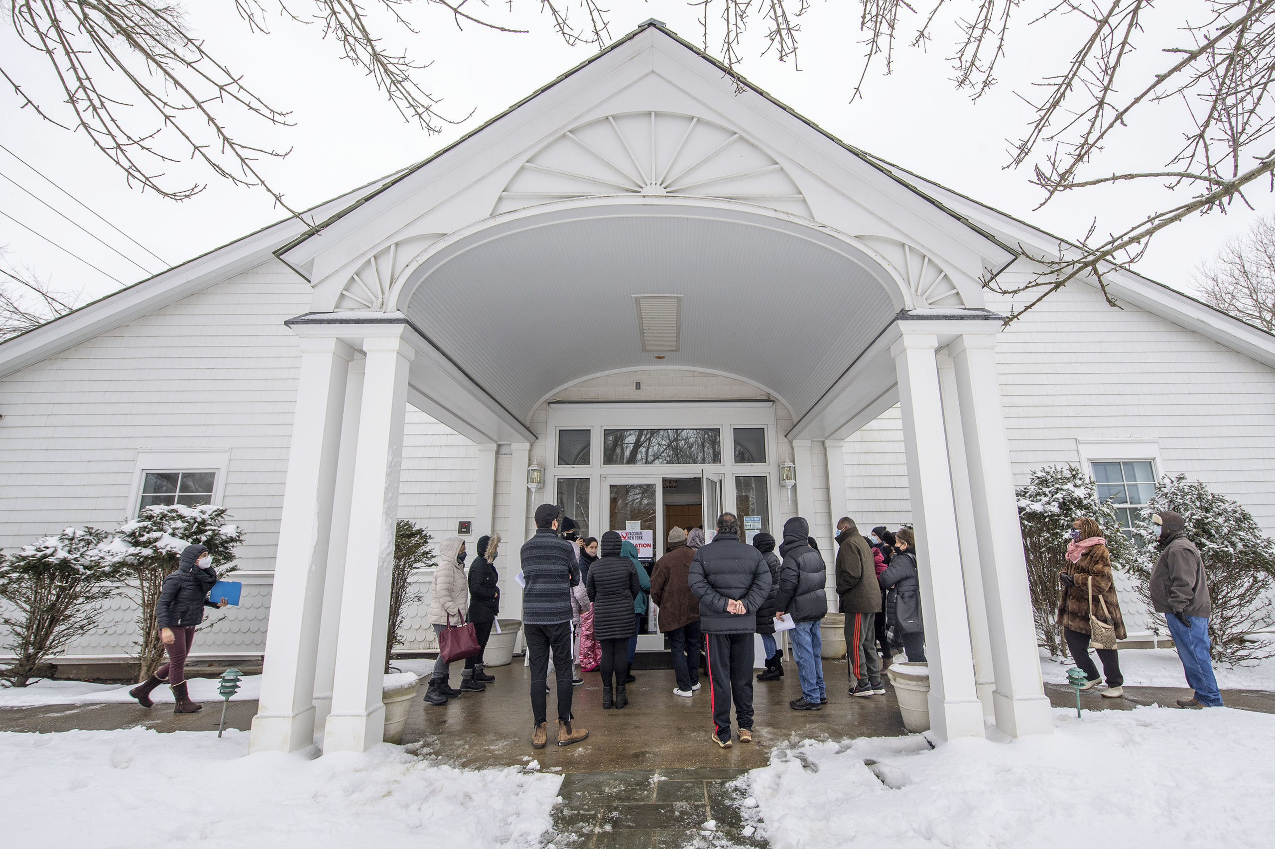 A crowd of people with appointments waits outside the hall during a COVID-19 vaccine POD (Pop Up Dispensary) organized by OLA (Organización Latino-Americana) in the Ryan Dempsey Parrish Hall of the Most Holy Trinity Church in East Hampton on Friday.    MICHAEL HELLER