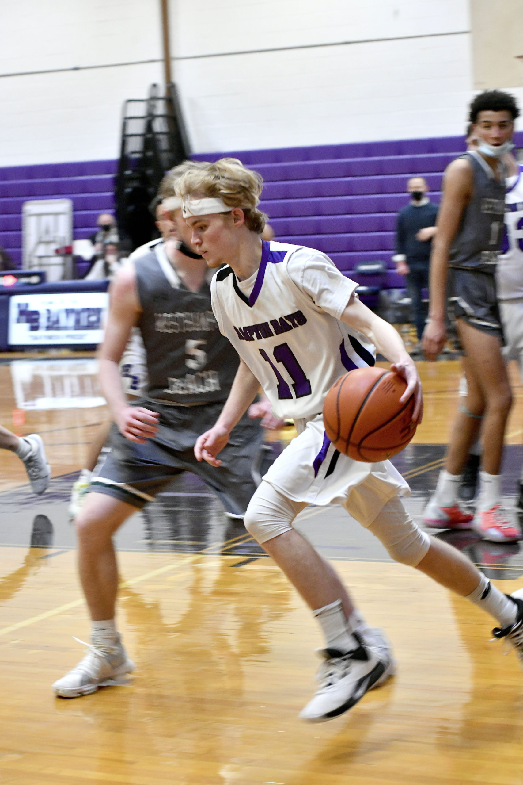 Hampton Bays senior point guard Jack McNamara moves the ball outside around Westhampton Beach's Nick Waszkelewicz.     DANA SHAW