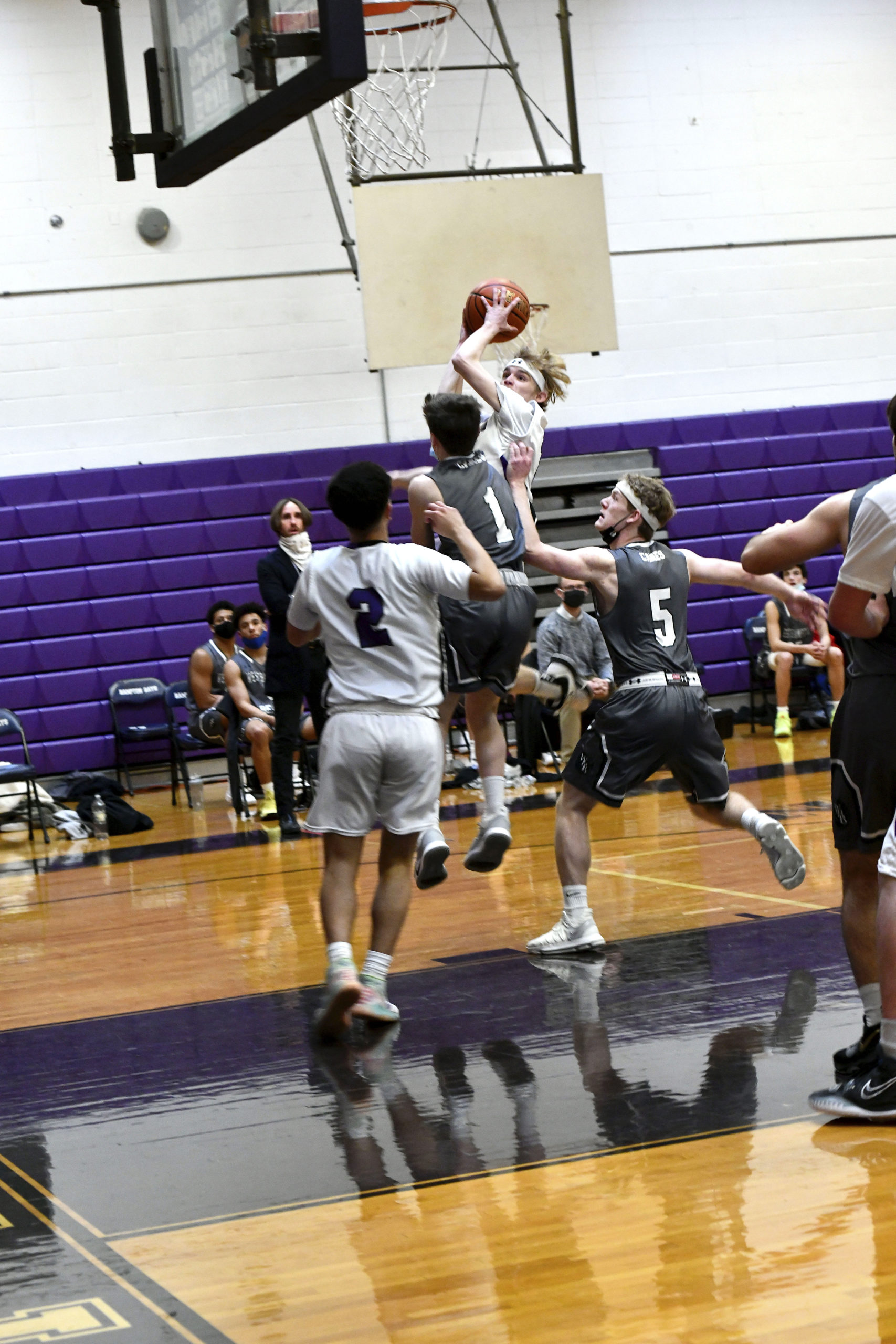 Hampton Bays senior point guard Jack McNamara leaps toward the basket over Westhampton Beach's Lou Hagopian and Nick Waszkelewicz. DANA SHAW