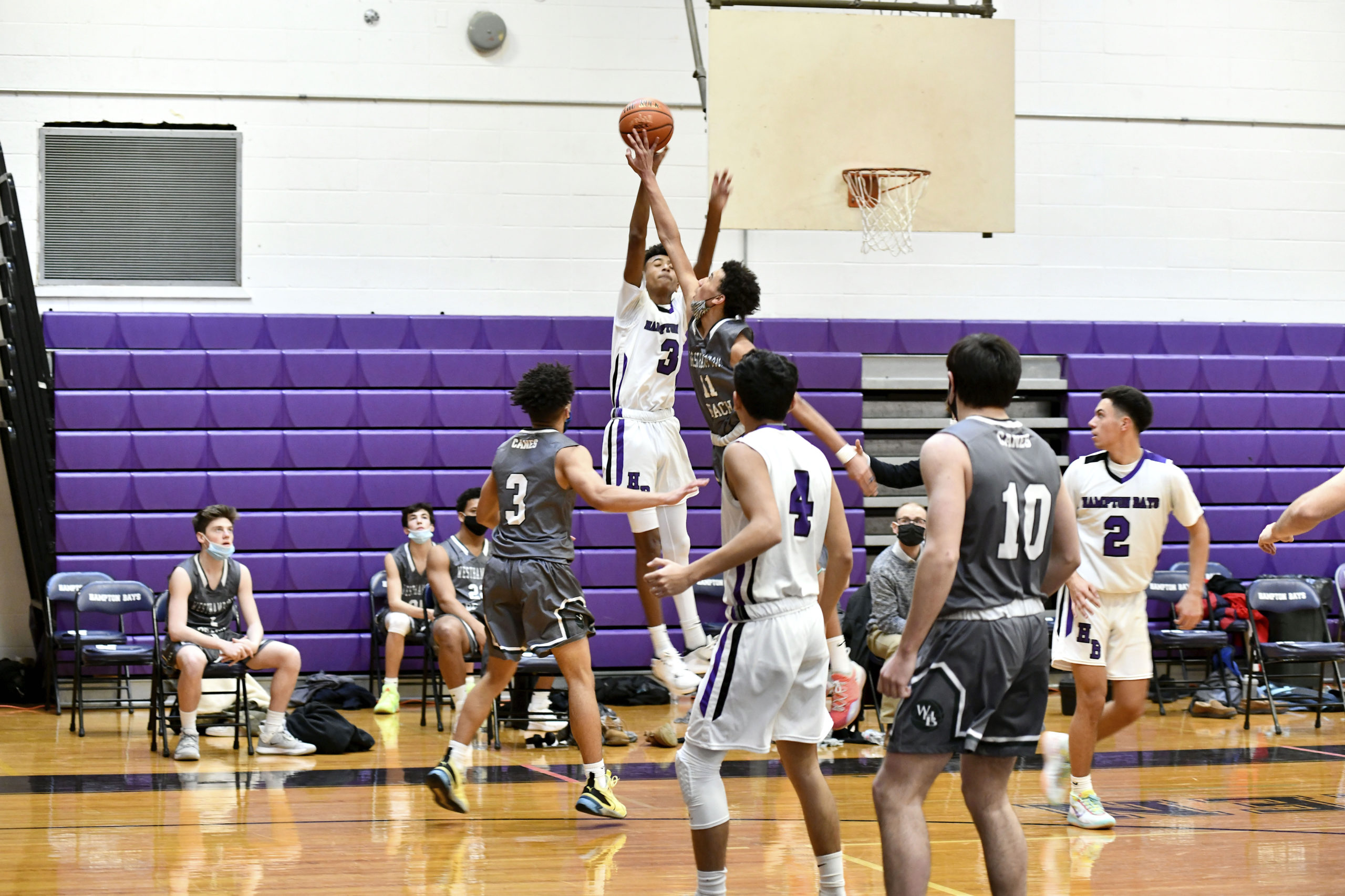 Hampton Bays sophomore Kazmir Johnson shoots from three-point range as Westhampton Beach's Cameron DePetris attempts a block.                      DANA SHAW