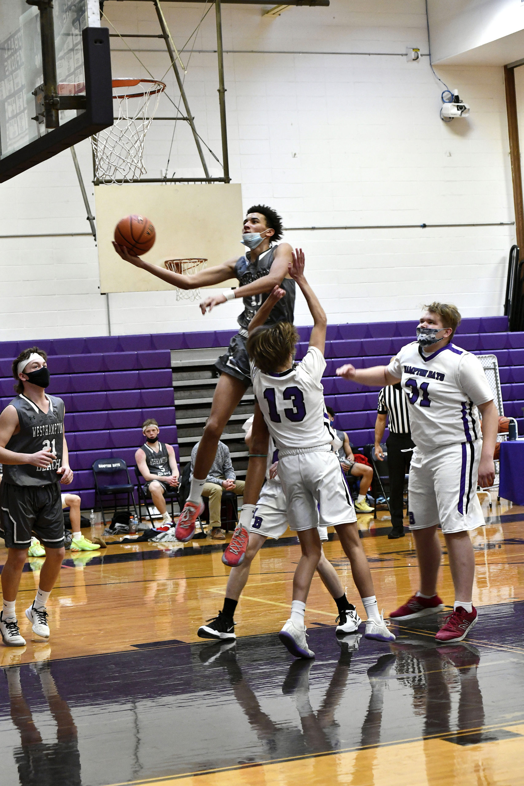 Westhampton Beach junior forward Cameron DePetris alley-oops over Hampton Bays' Stephen Sutton.                   DANA SHAW