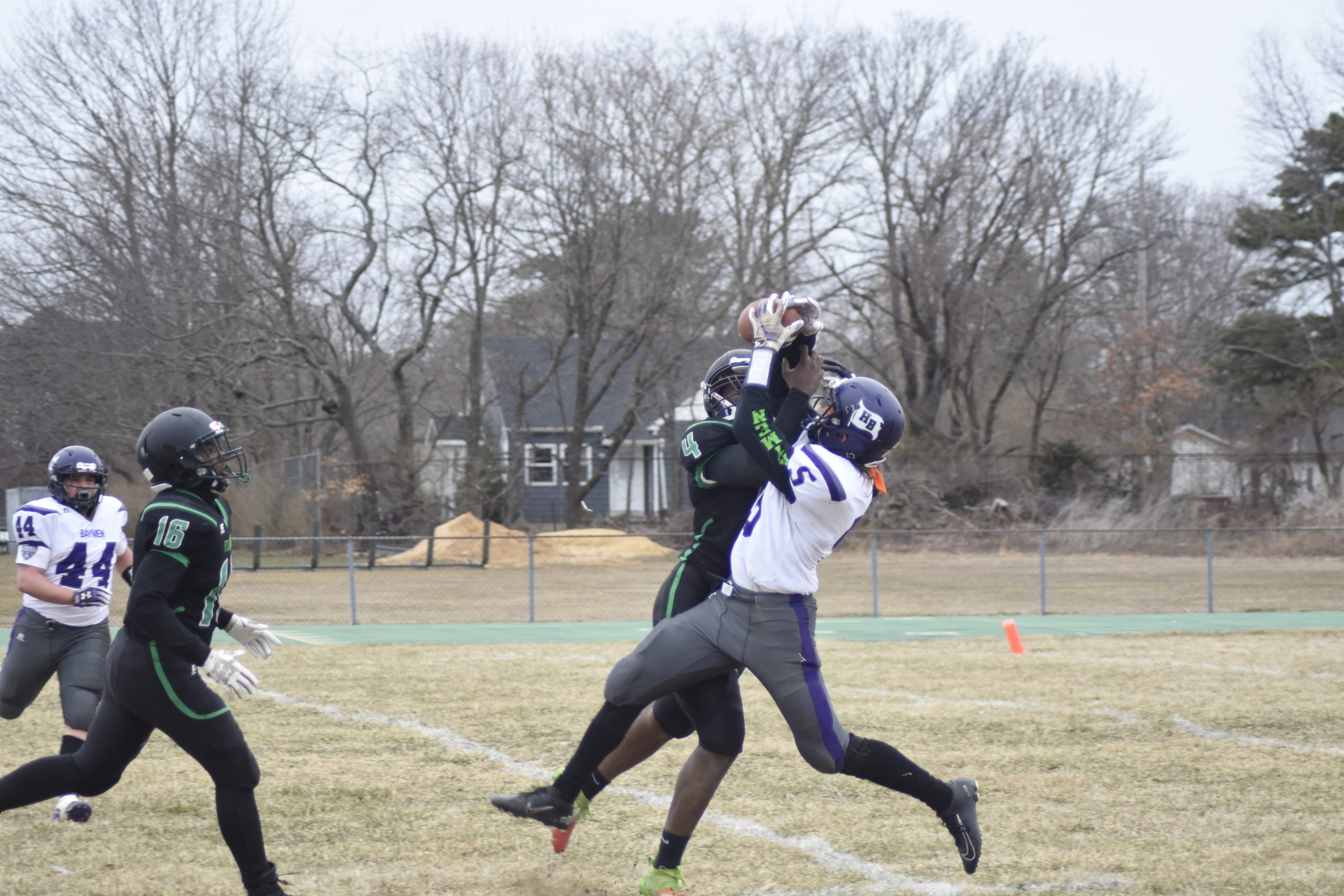 Hampton Bays senior receiver Mickey Bracken makes a catch over Wyandanch senior DeAndre Smith.