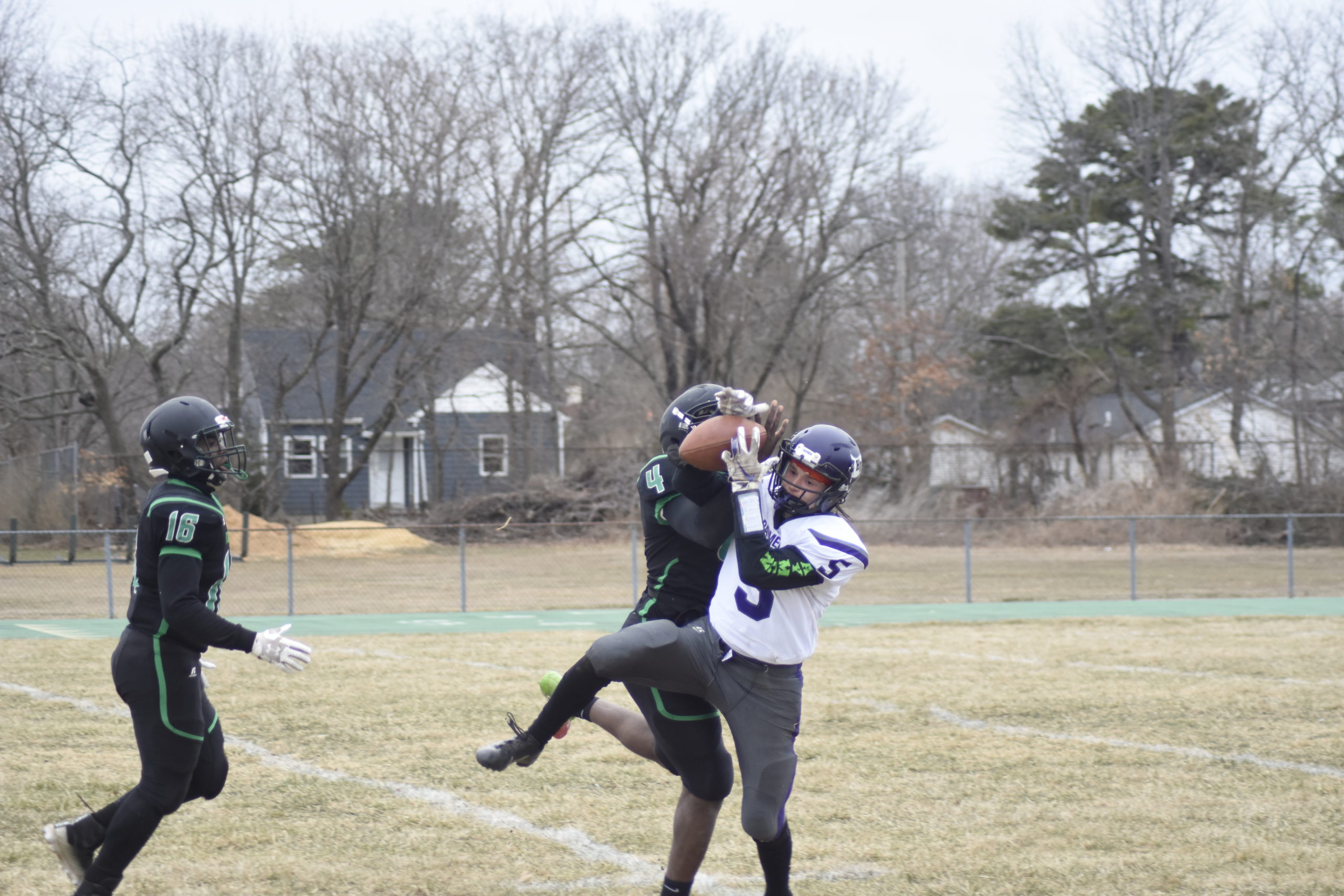 Hampton Bays senior receiver Mickey Bracken makes a catch over Wyandanch senior DeAndre Smith.