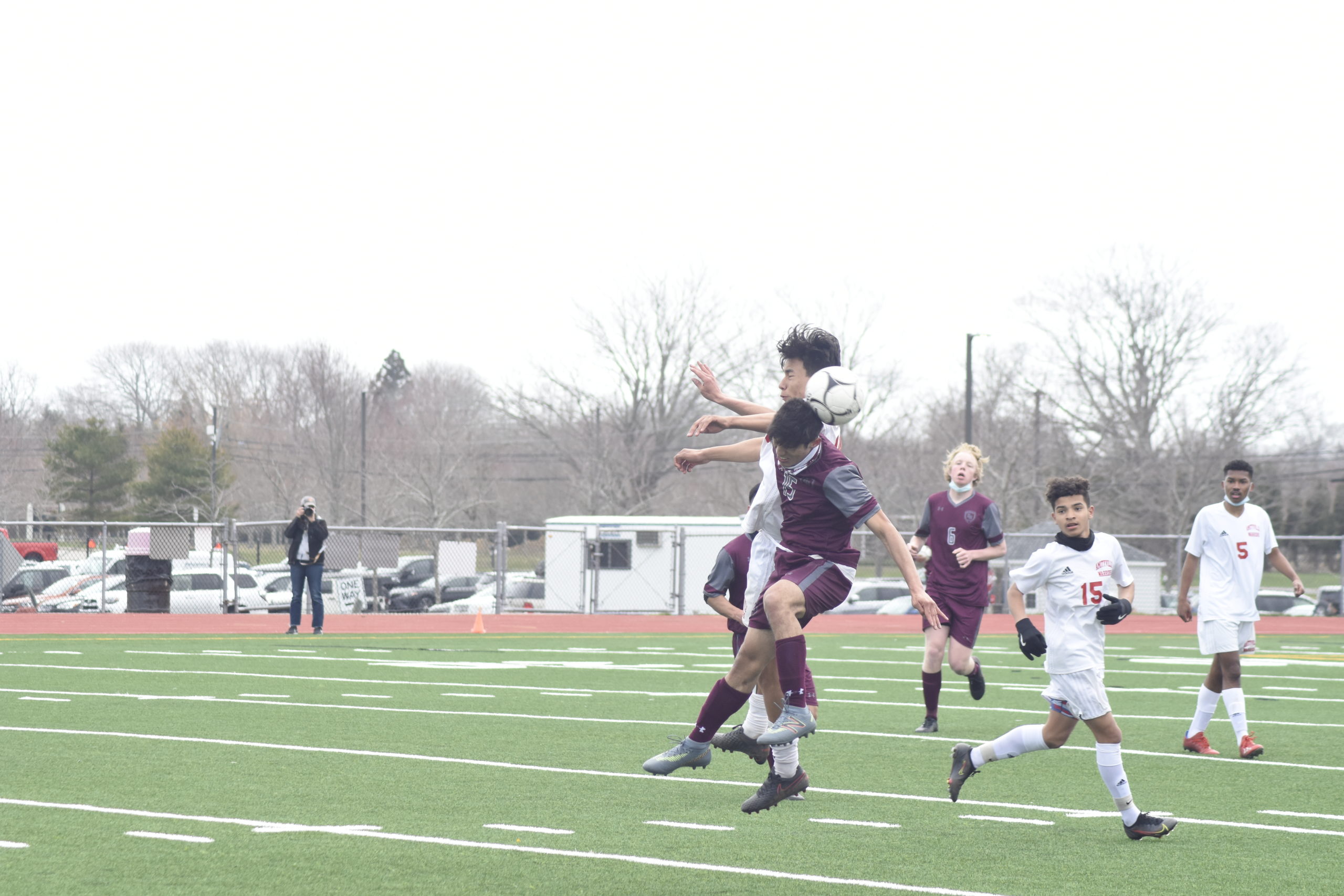 East Hampton senior Alex Vanegas goes up with an Amityville player to try and head the ball.