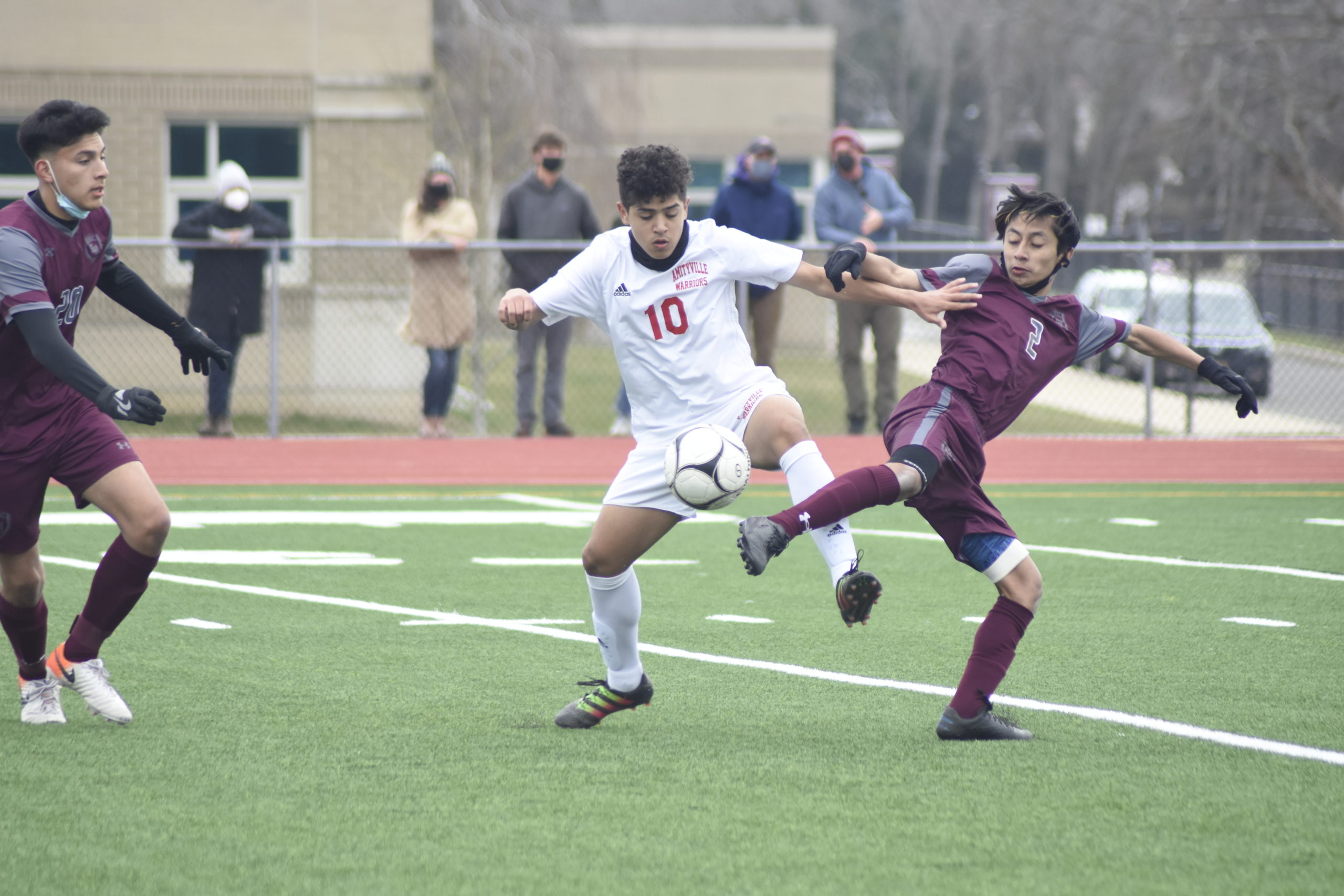 East Hampton senior Robert Velez and an Amityville player get tangled up trying to go for the ball.