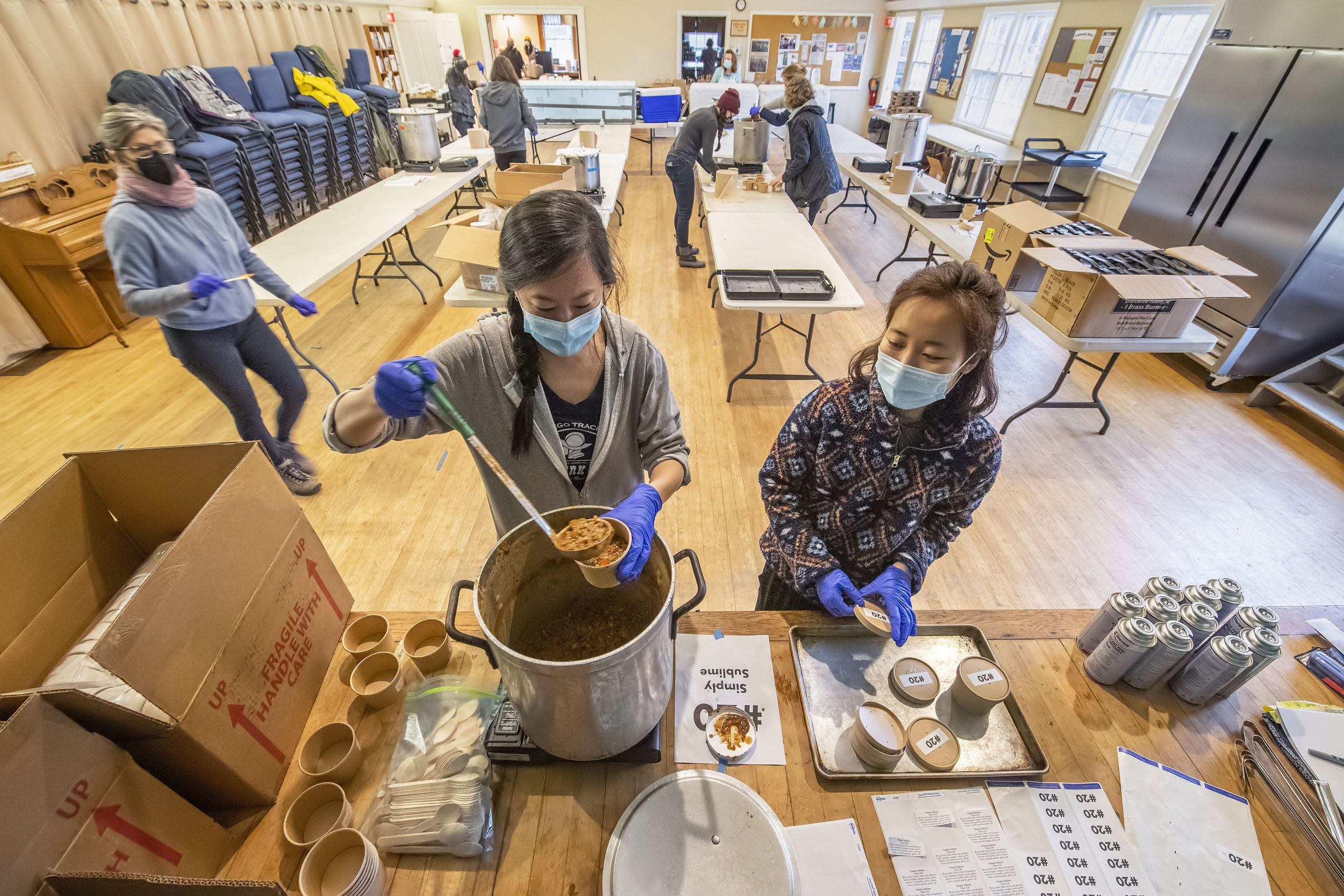 Elise Hsu and Jenny Park fill containers of chili made by Simply Sublime during the annual Chili Cook Off that was held at the Springs Presbyterian Church on Saturday.     MICHAEL HELLER