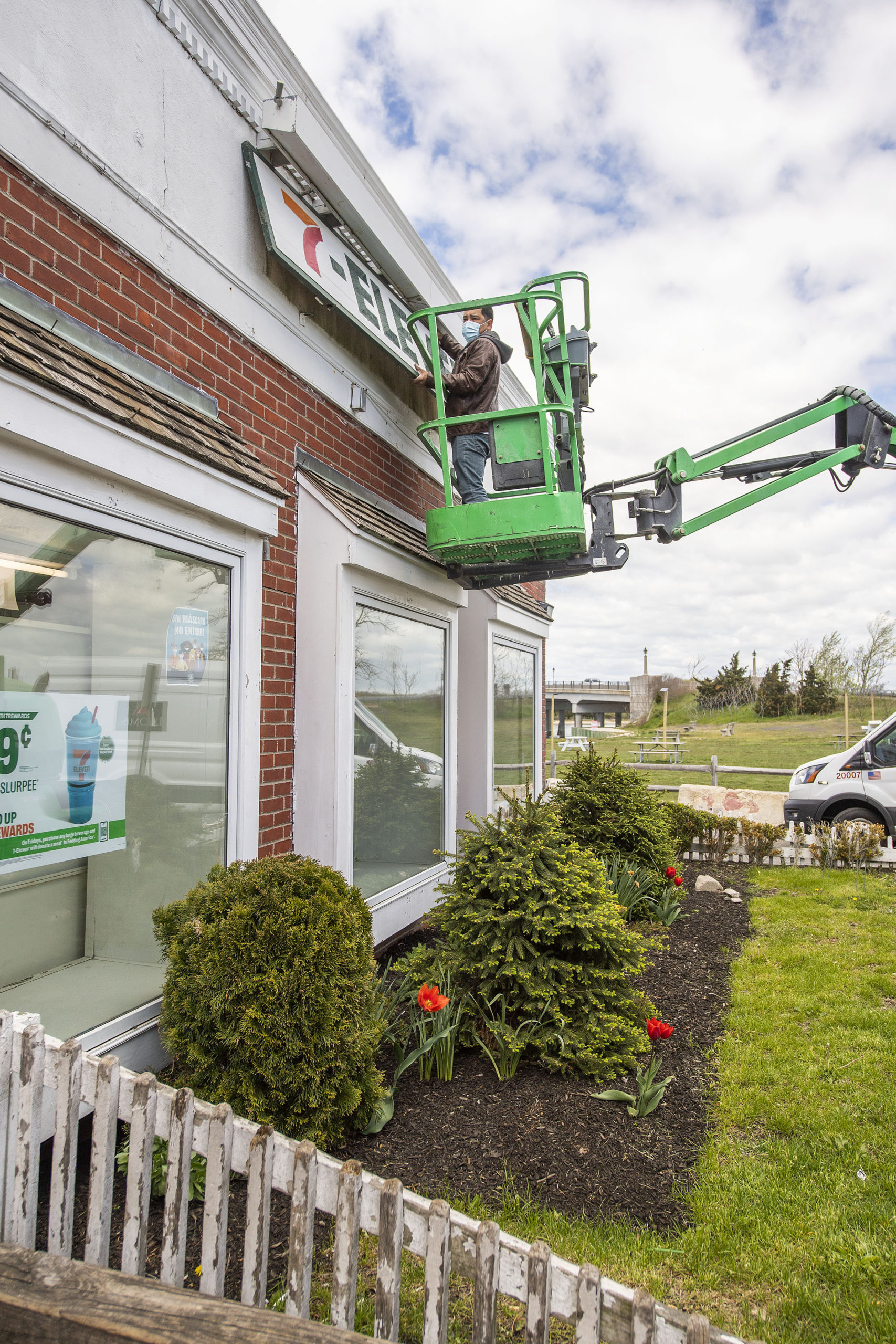 A worker removes the sign from the Sag Harbor 7-Eleven, which closed on Friday. MICHAEL HELLER