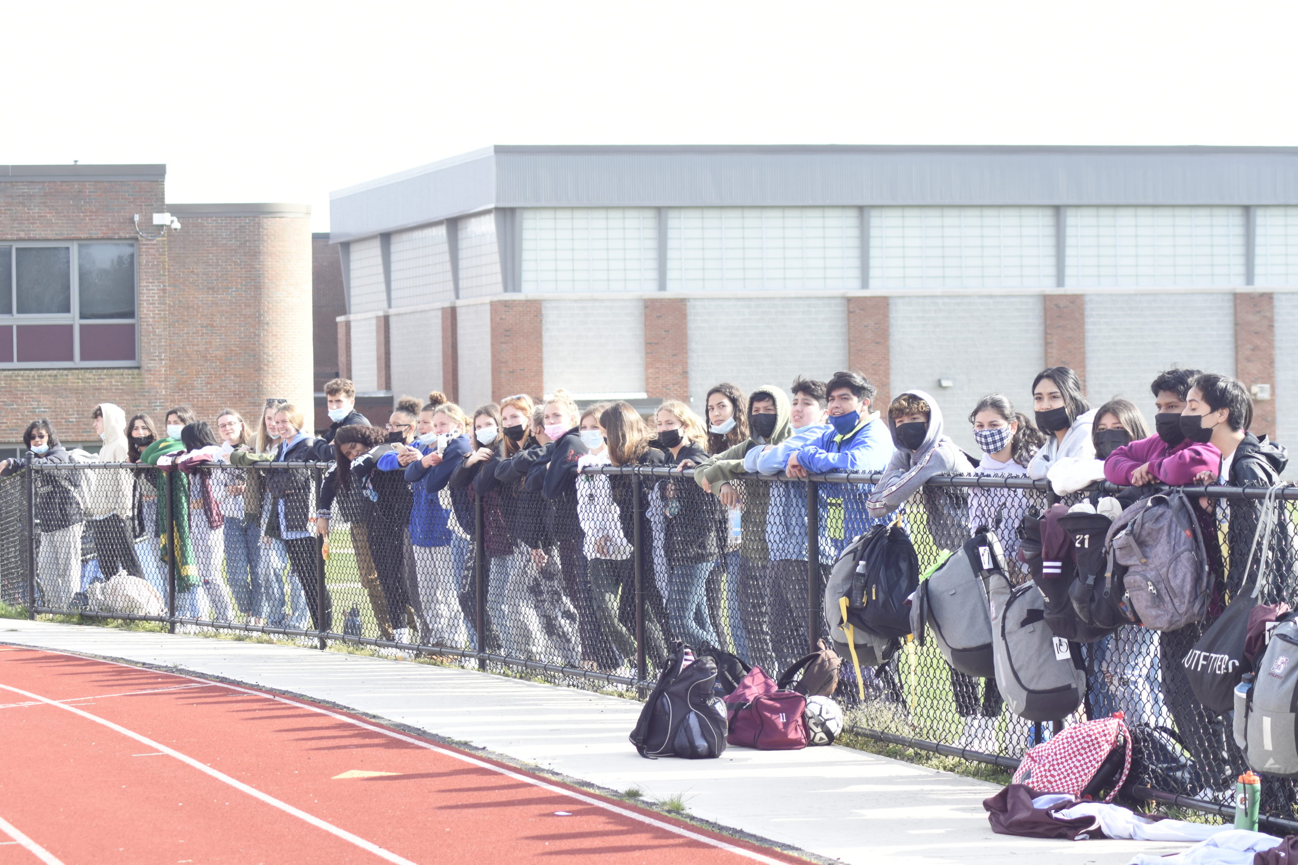Southampton students line the outside of the track, cheering on their classmates in Wednesday's boys soccer playoff game.