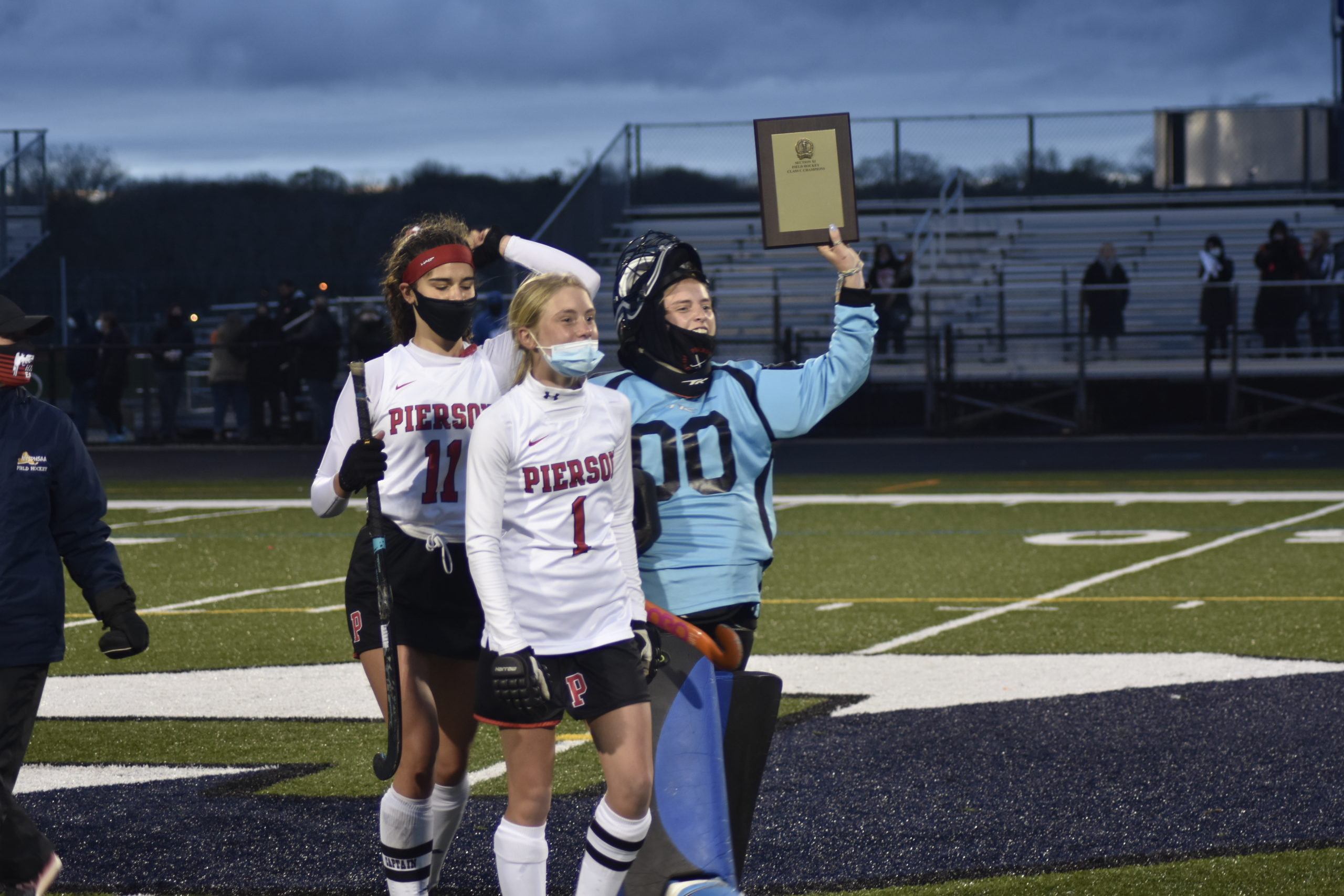 Pierson tri-captains, from left, Meredith Spolarich, Brooke Esposito and Grace Perello hoist the county championship plaque.