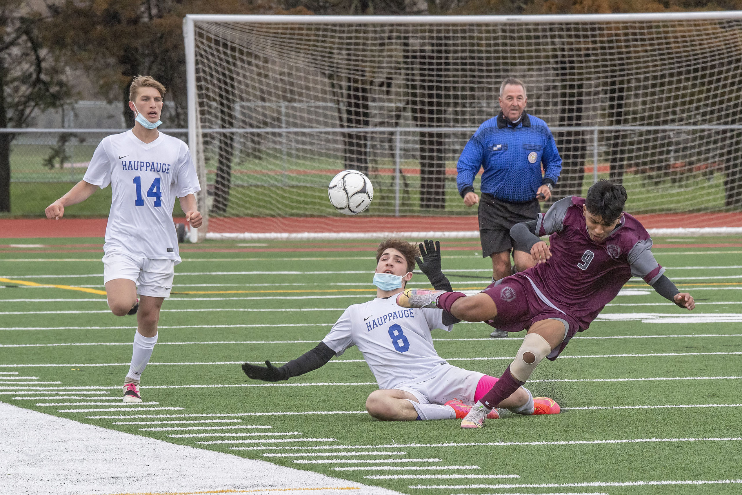 East Hampton sophomore Eric Armijos and a Hauppauge player both go down to the turf.