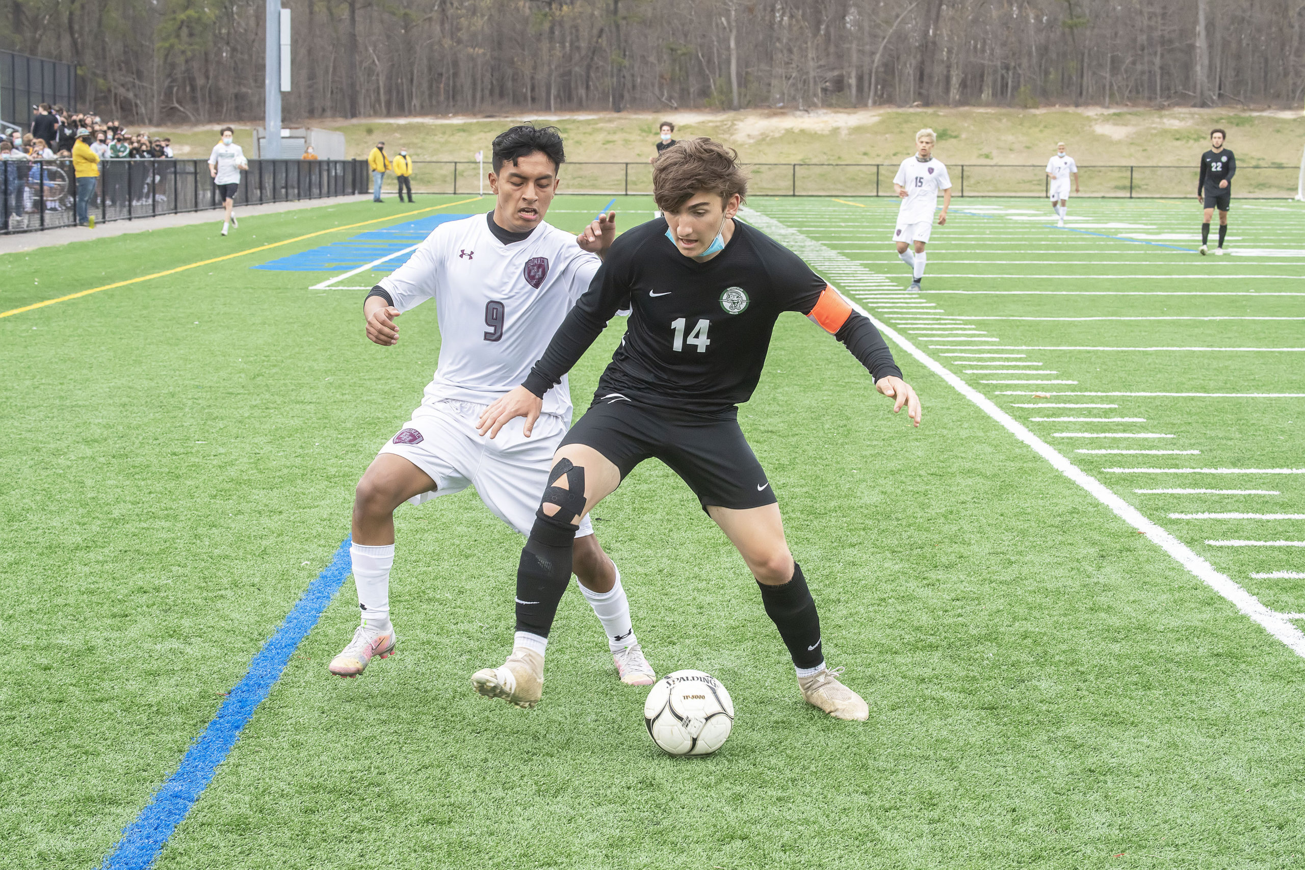 East Hampton's Eric Armijos fights for the ball with Aidan Cuthbertson of Harborfields.