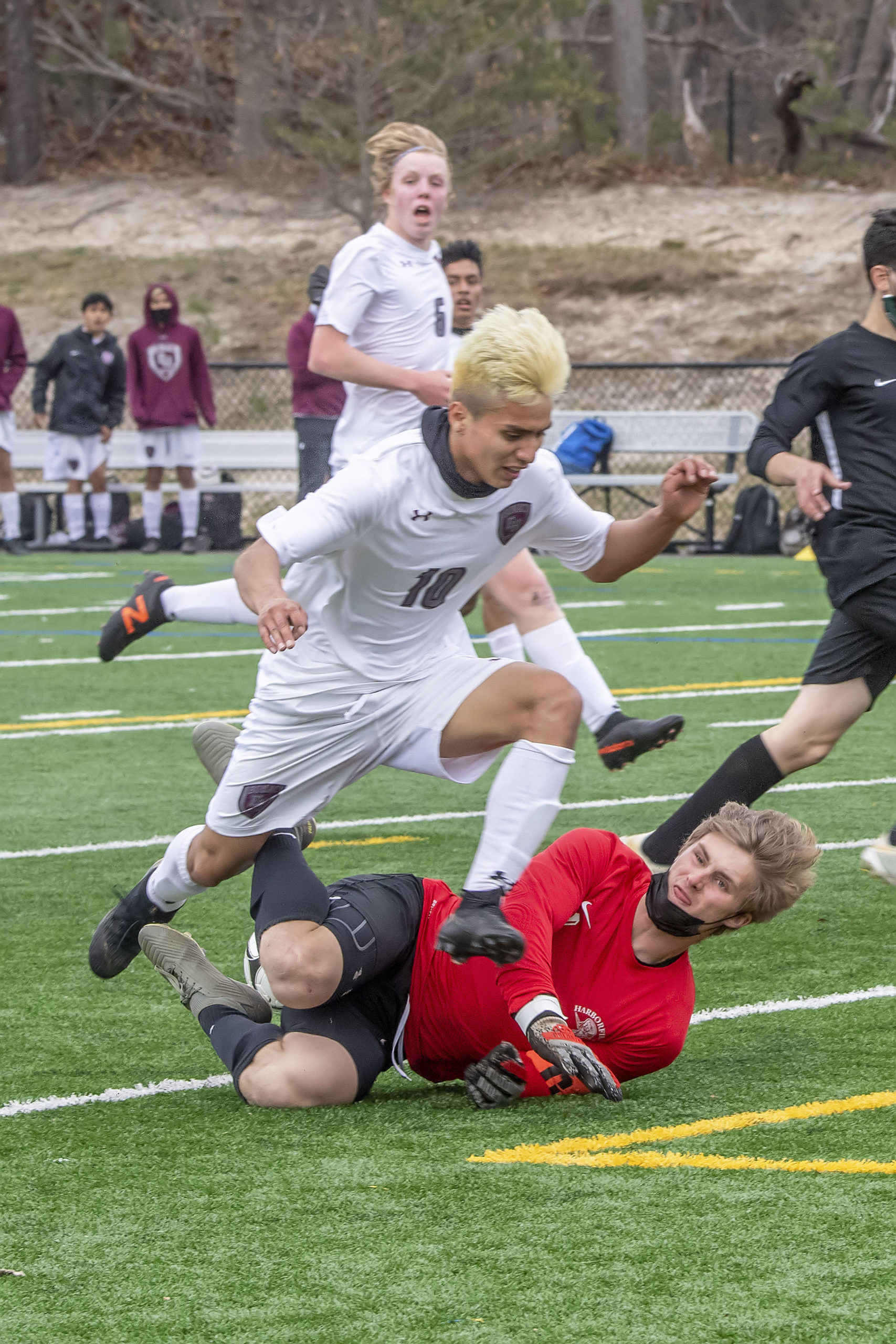 East Hampton's Christopher Pintado collides with Harborfields goalkeeper Ryan Steel after a breakaway.