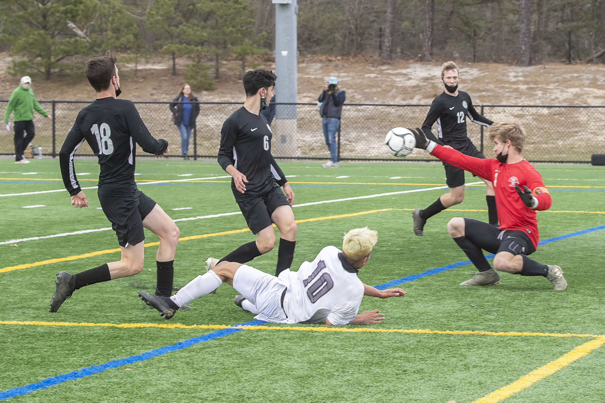 Harborfields goalie Ryan Steel gets a hand on East Hampton's Christopher Pintado's shot.