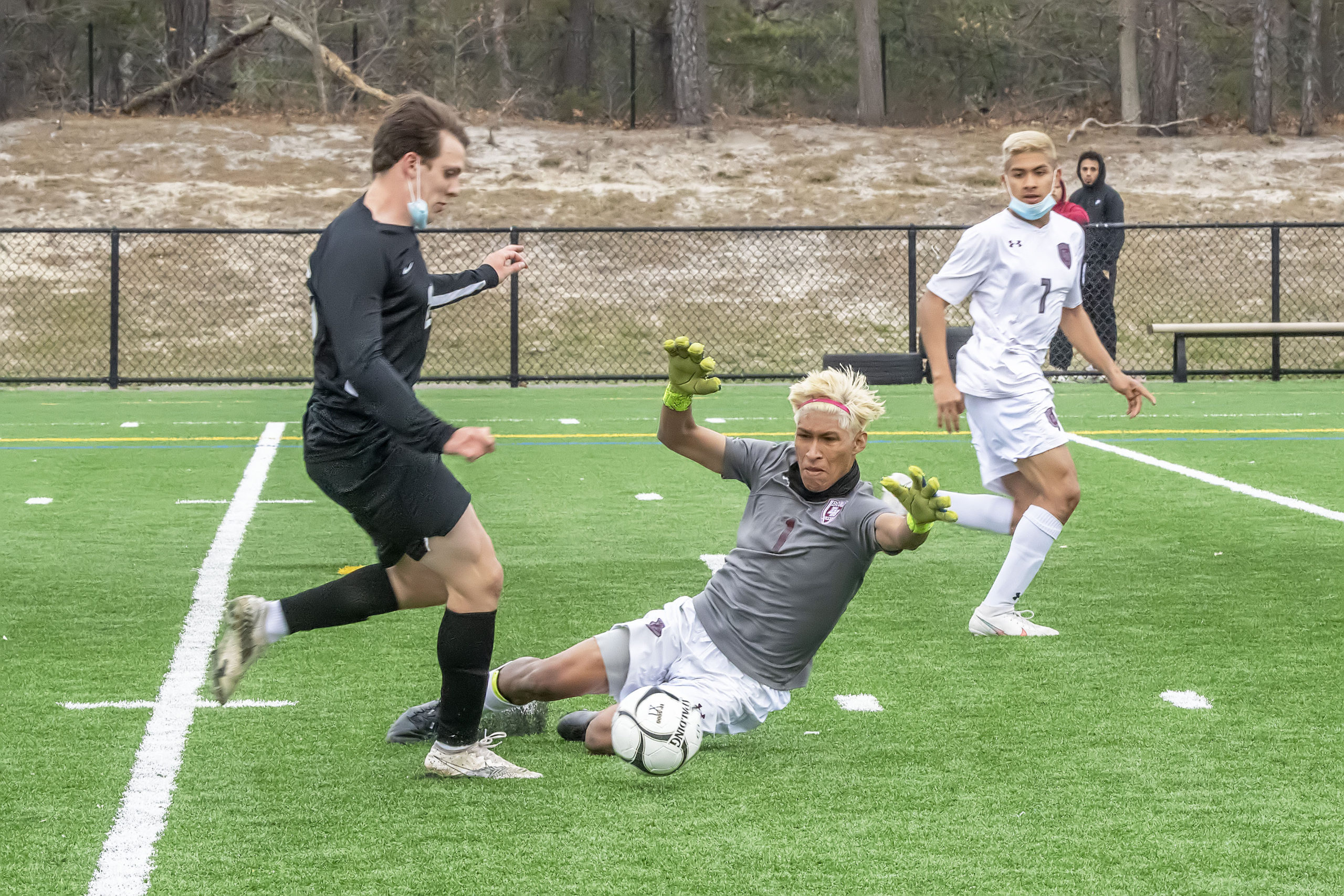 East Hampton goalie Christopher Barahona moves to block a shot on goal by Harborfields forward Tyler Axelsen after a fast break.