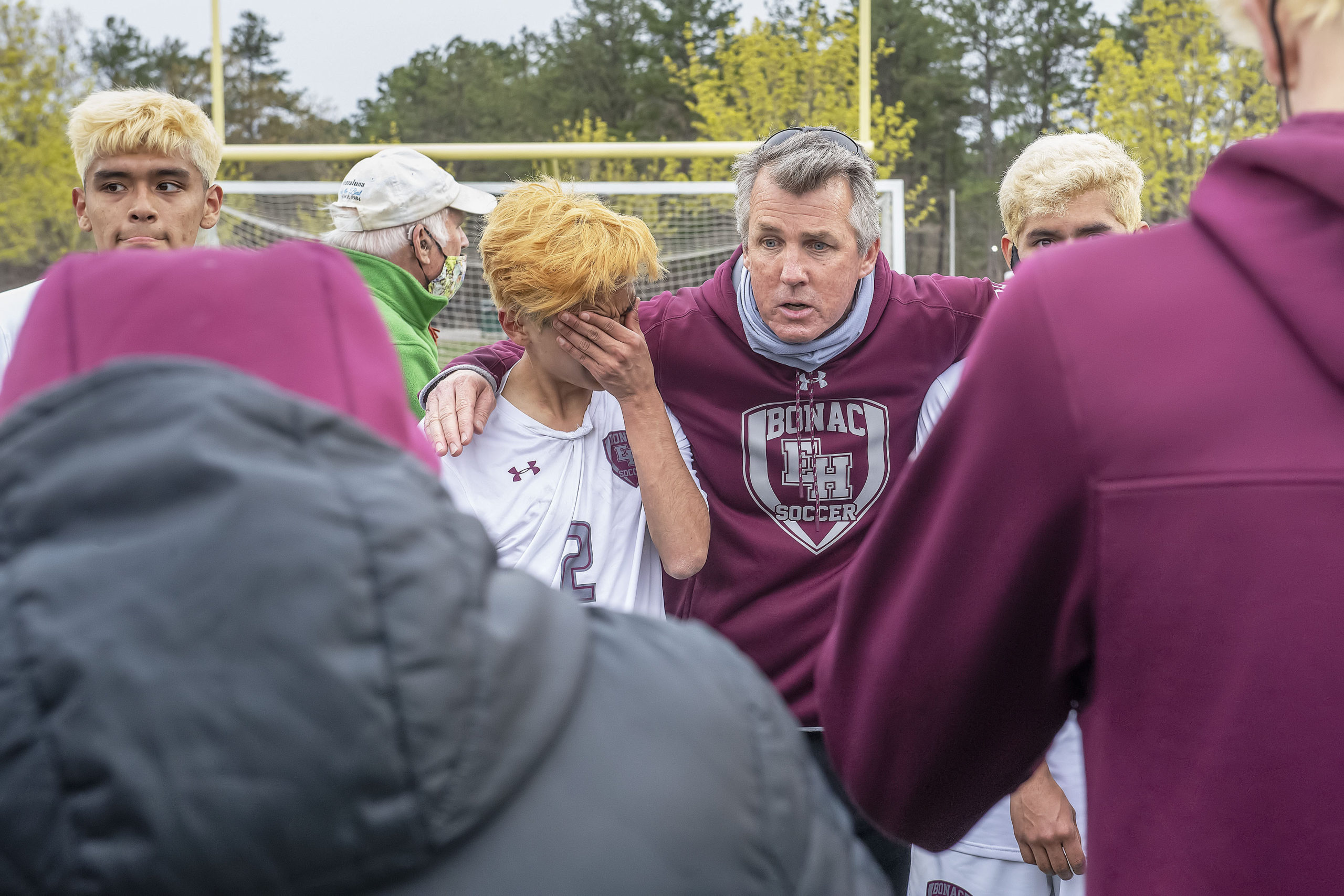 East Hampton head coach Don McGovern comforts a weeping Robert Velez and the rest of his teammates after losing the Suffolk County Class A Soccer final on Saturday.