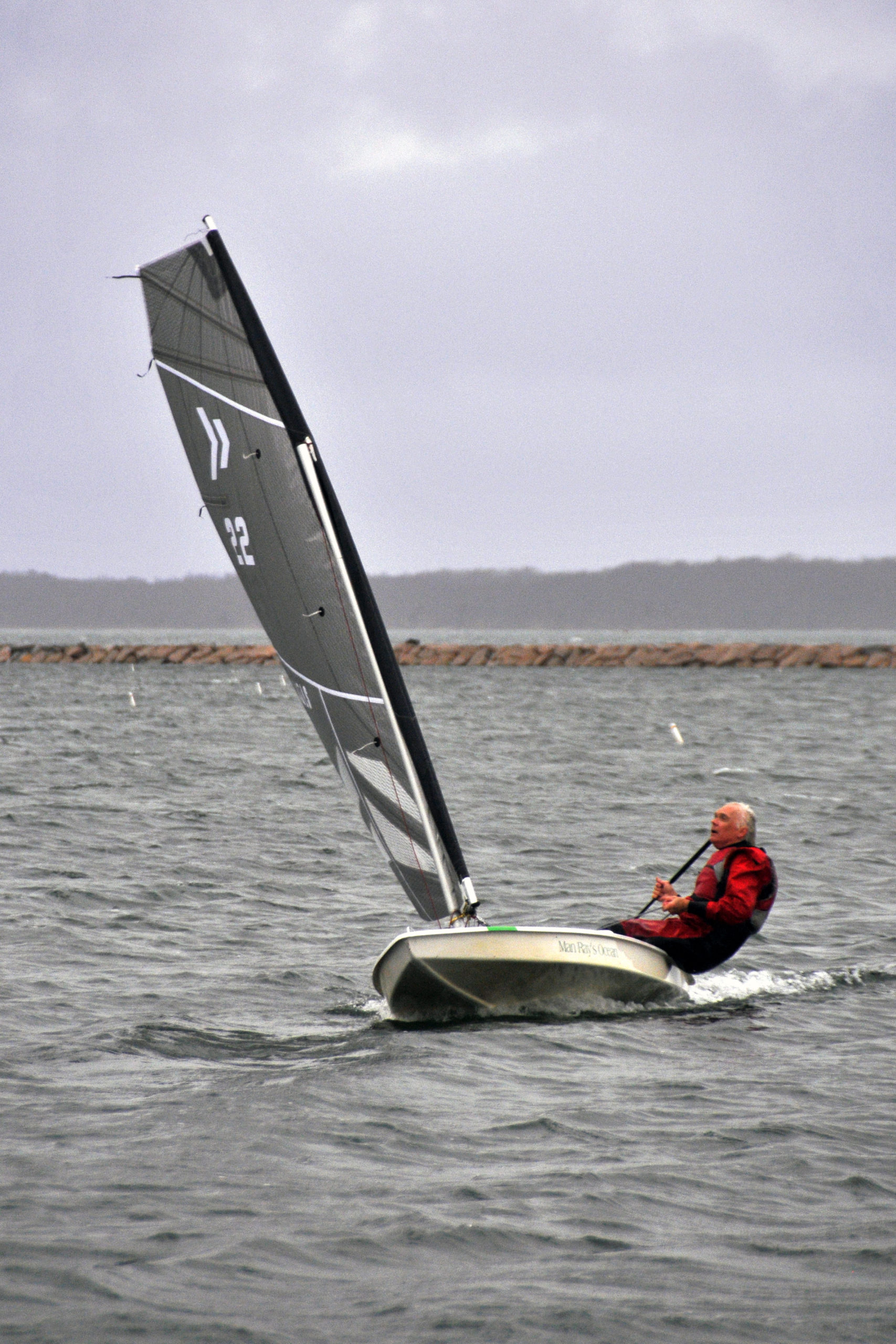 Scott Sandell felt an ardent desire to demonstrate his new black carbon fiber sail to fellow club members, and he did just that. The chase boat covered his every tack and jibe as he careened solo around the inner harbor at breakneck, planning speeds.