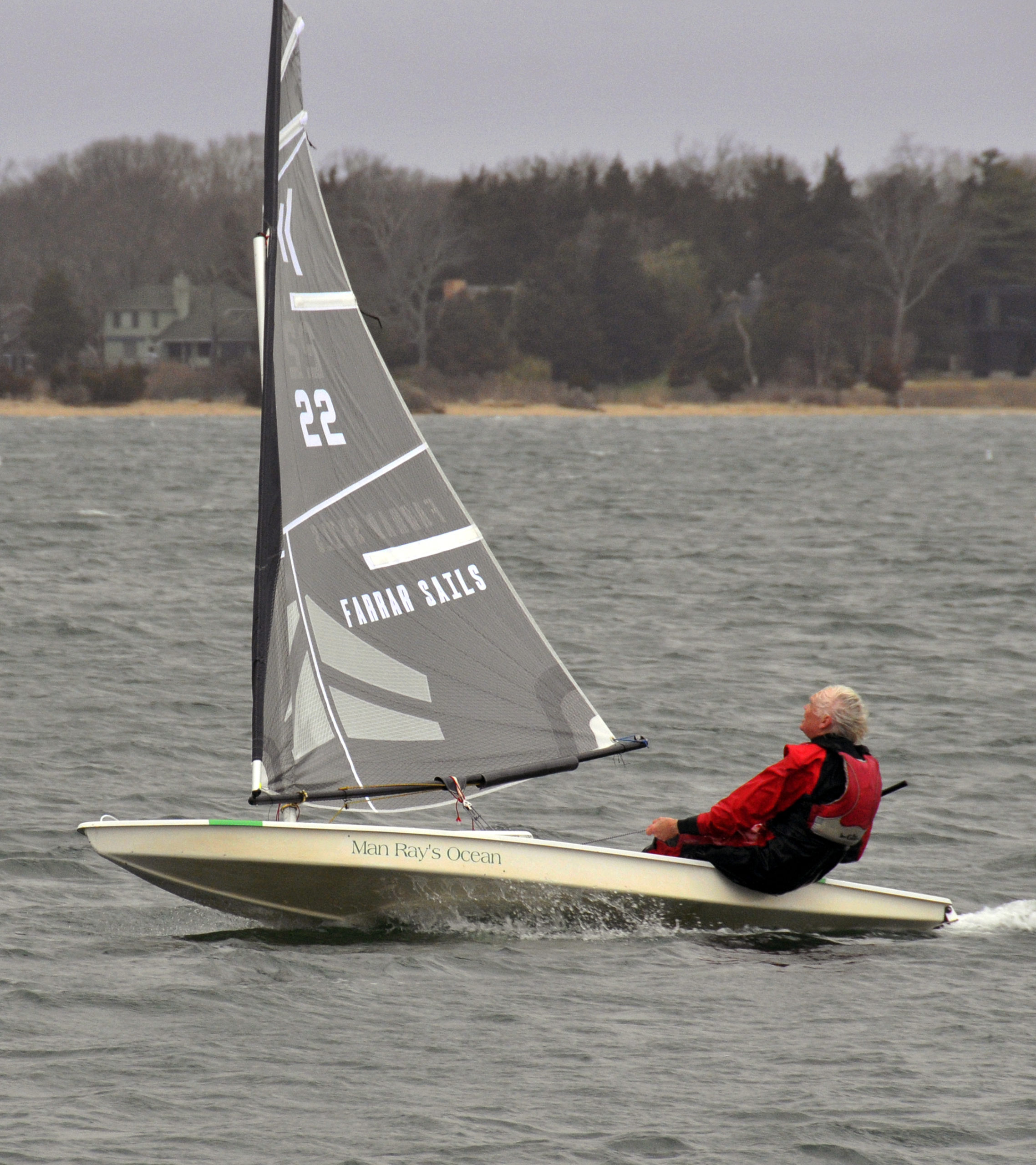 Scott Sandell felt an ardent desire to demonstrate his new black carbon fiber sail to fellow club members, and he did just that. The chase boat covered his every tack and jibe as he careened solo around the inner harbor at breakneck, planning speeds.