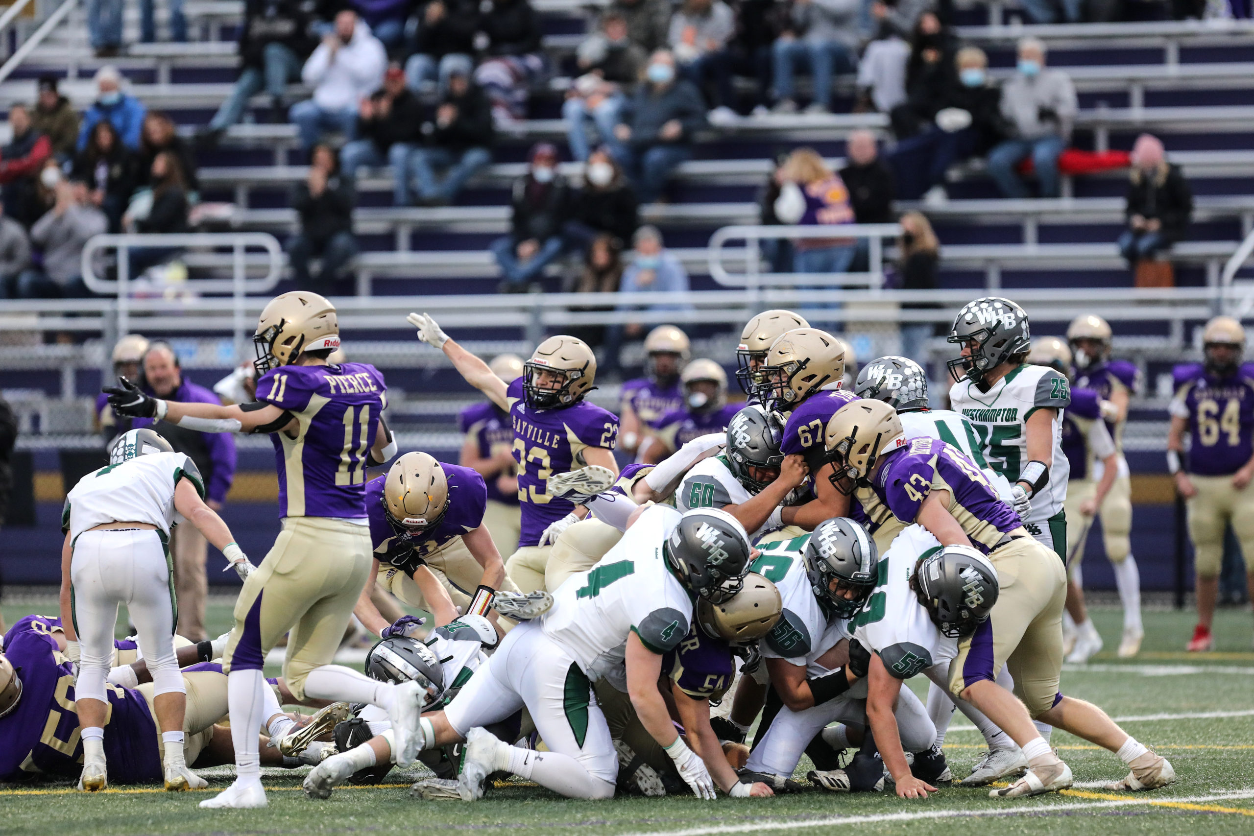 Westhampton Beach and Sayville football players pile up on a loose ball.