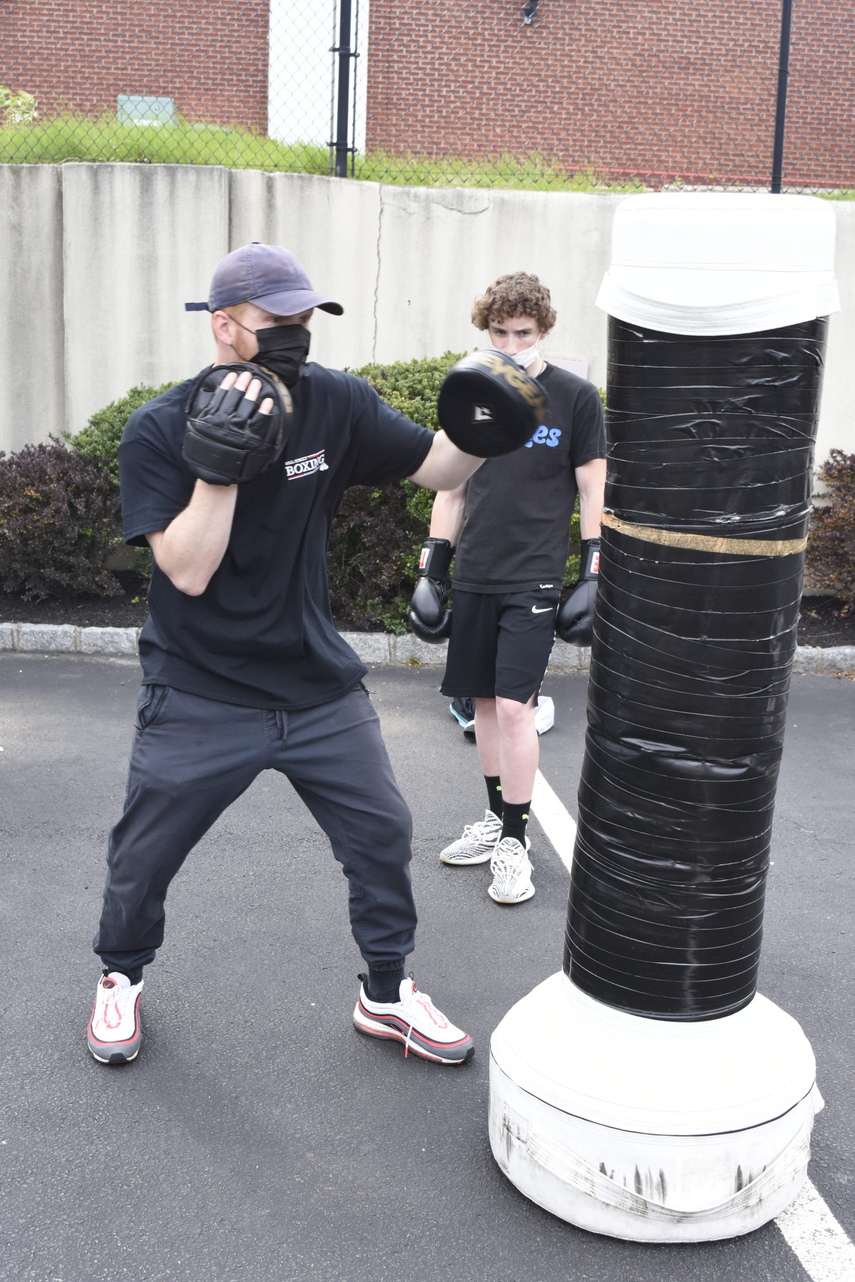 Avery Crocker shows Hampton Bays student Chandler Tuttle some boxing techniques.