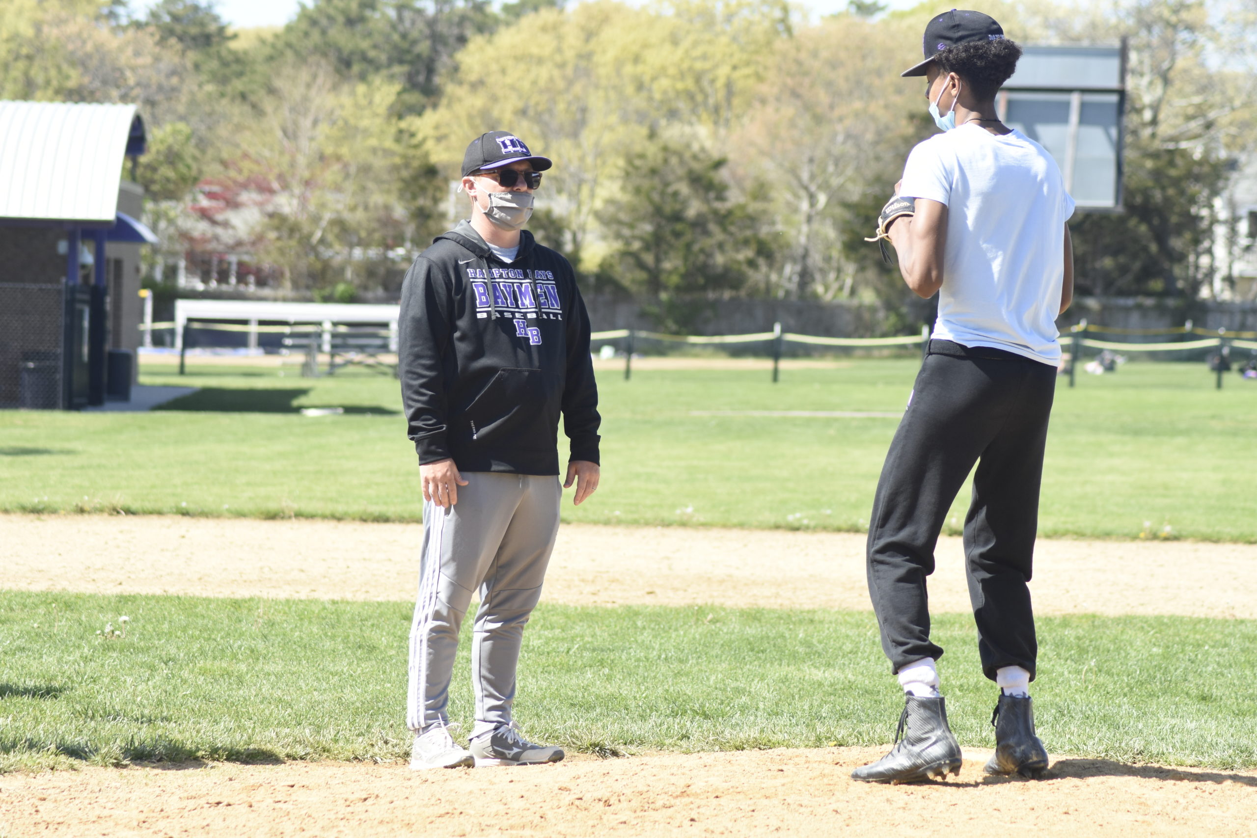 Hampton Bays head coach John Foster going over pick-off moves with his pitcher in practice on Thursday, May 6.