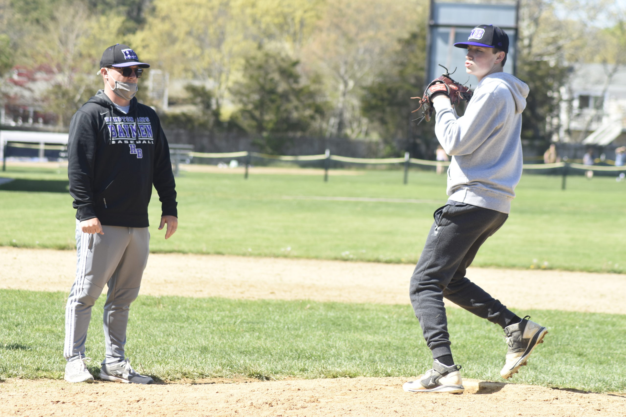 Hampton Bays head coach John Foster going over pick-off moves with his pitcher in practice on Thursday, May 6.