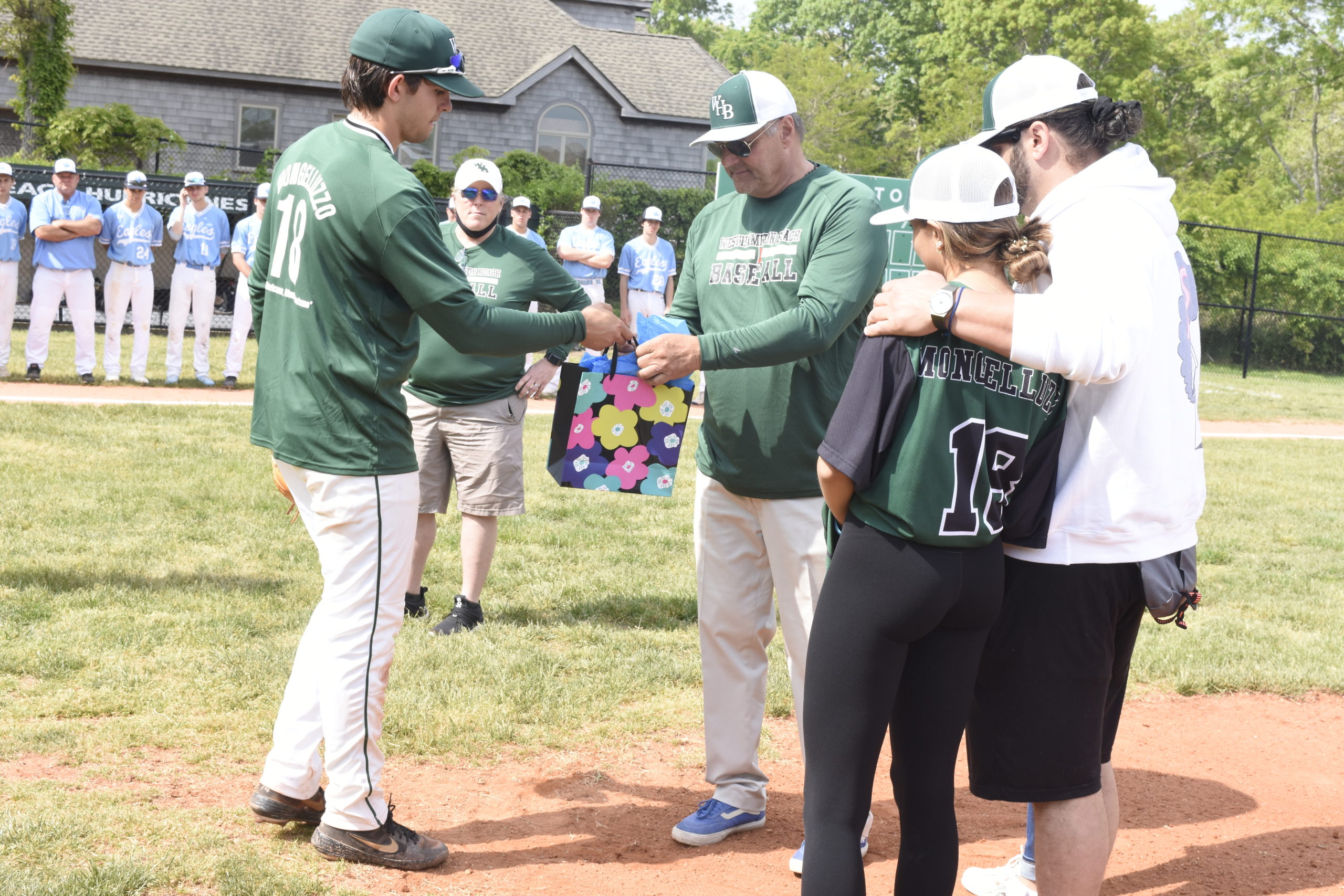 Westhampton Beach senior Jack Halloran hands a gift from the varsity baseball team to Michael Mongelluzzo and his family.