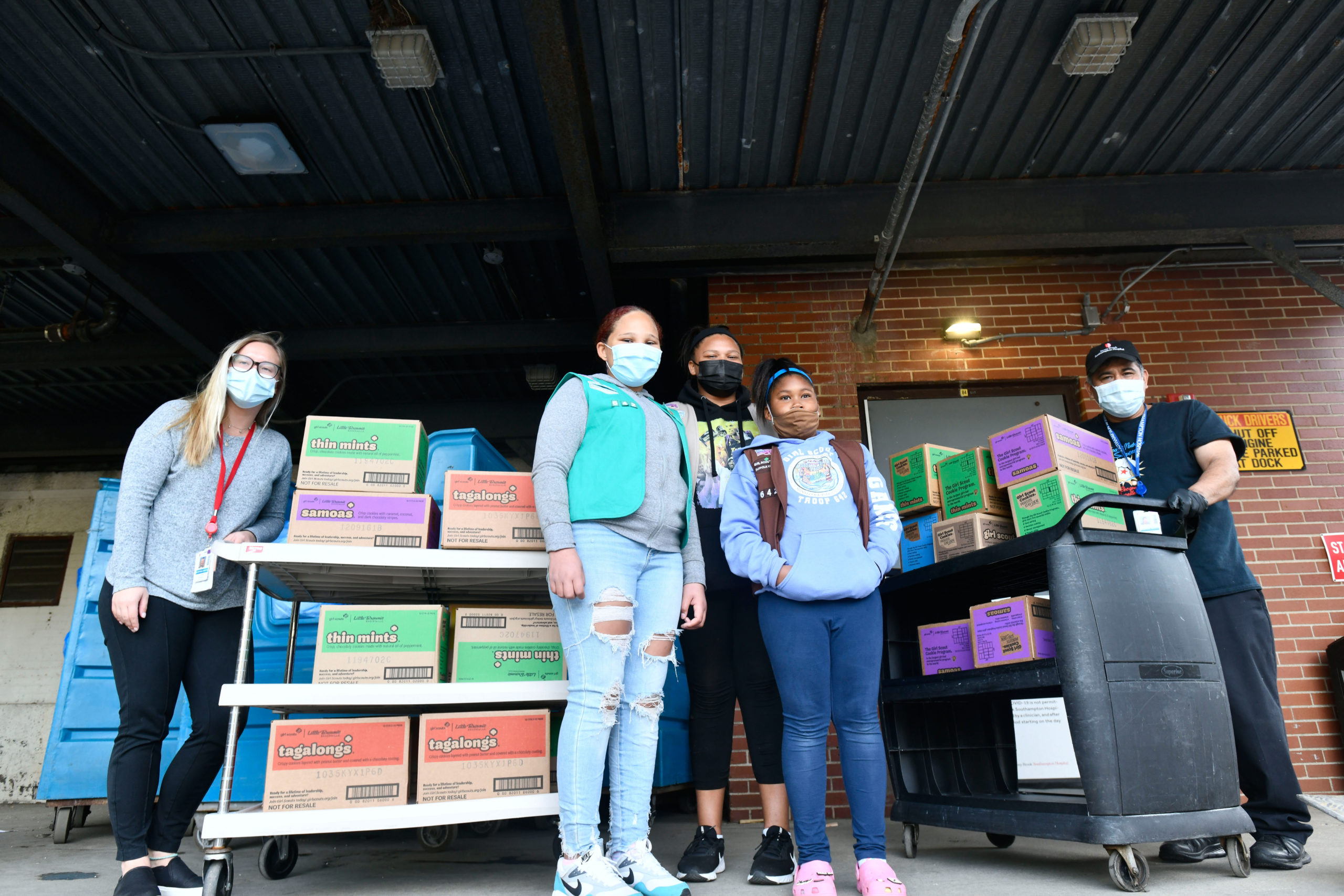 Members of Girl Scout Troop 642, Gabriella Gaines, Syvana Smith and Jordyn Smith, from the Shinnecock Nation dropped off 300 boxes (25 cases) of Girls Scout Cookies for the employees at Stony Brook Southampton Hospital on Sunday. May 2. Helping the girls unload are hospital employees Victoria Stanek and Cesar Flores.  DANA SHAW