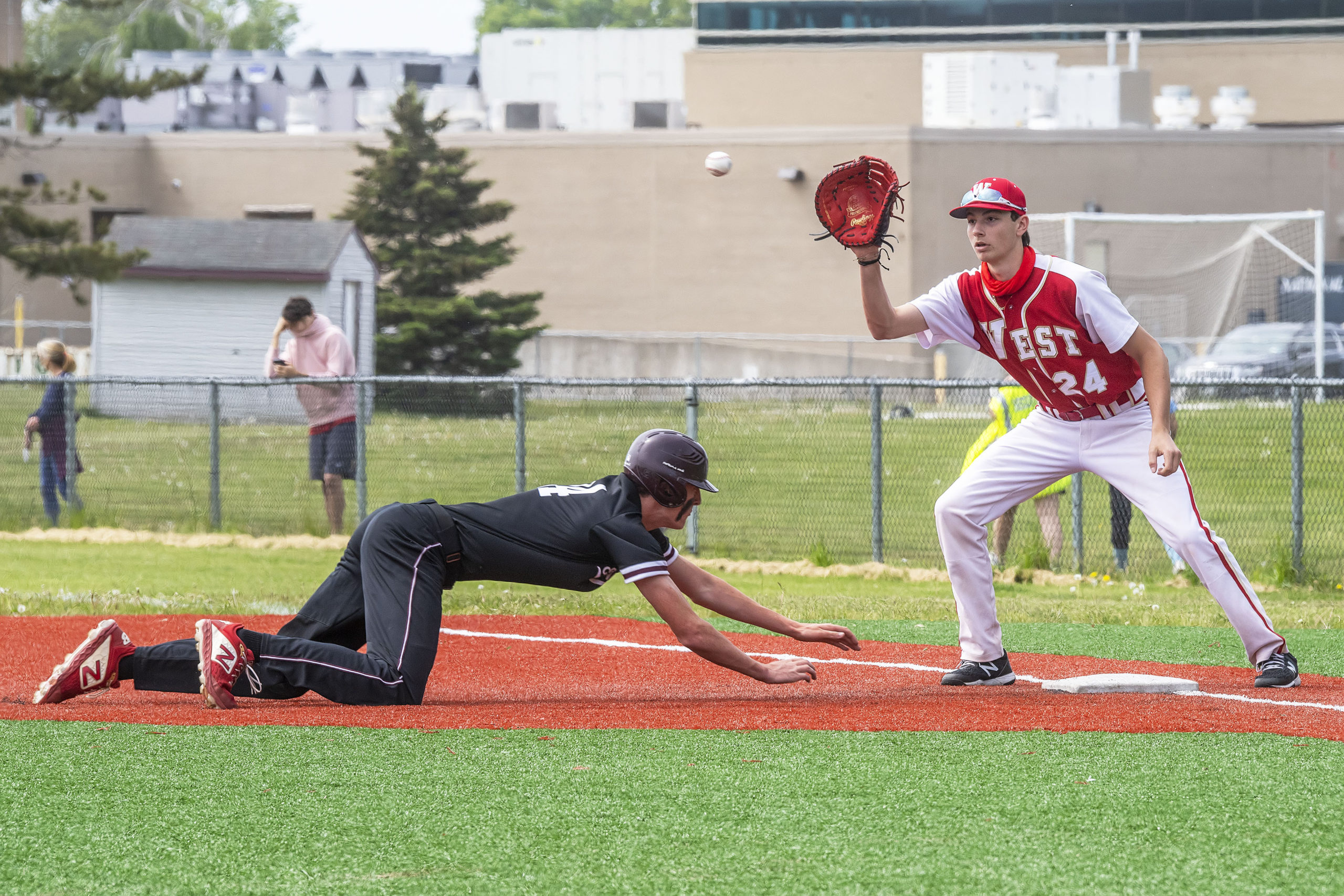 East Hampto's Charlie Condon slides back to first base safely following a pick-off play.