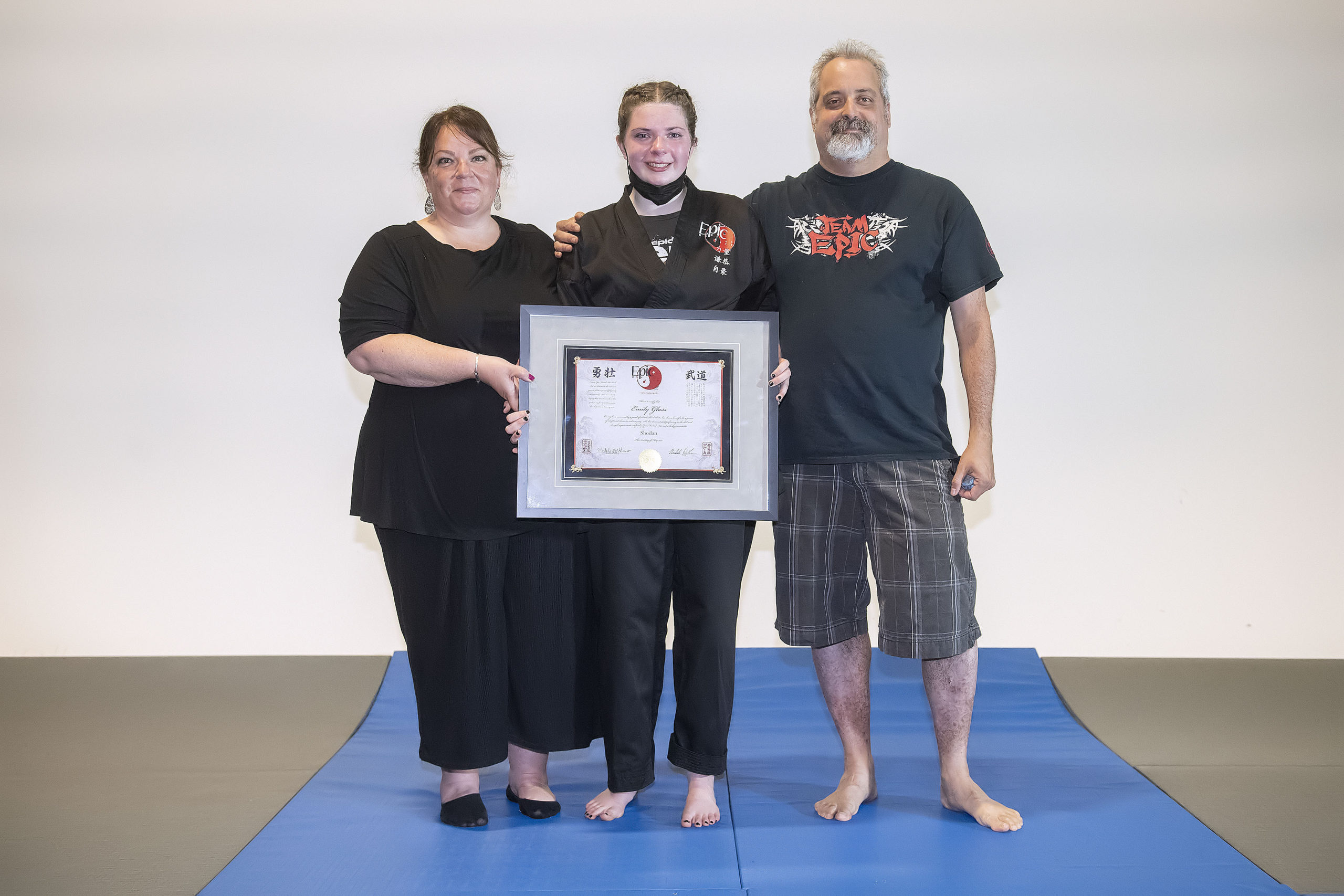 Emily Glass with her parents Jennifer and Dan after receiving her black belt on Sunday.