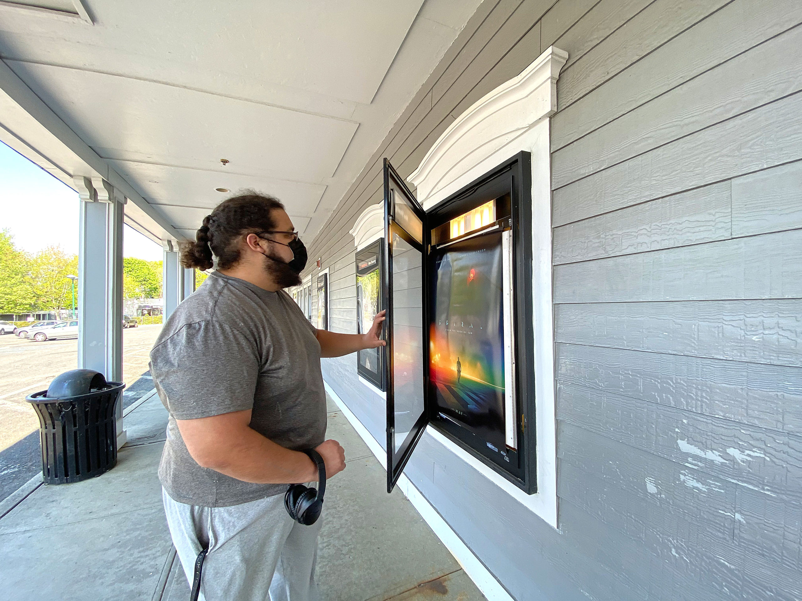 An employee replaces the now showing posters at the Hampton Bays United Artists movie theater on Monday. The theater is set to reopen May 21 under the company’s “CinemaSafe” COVID-19 guidelines.  DANA SHAW