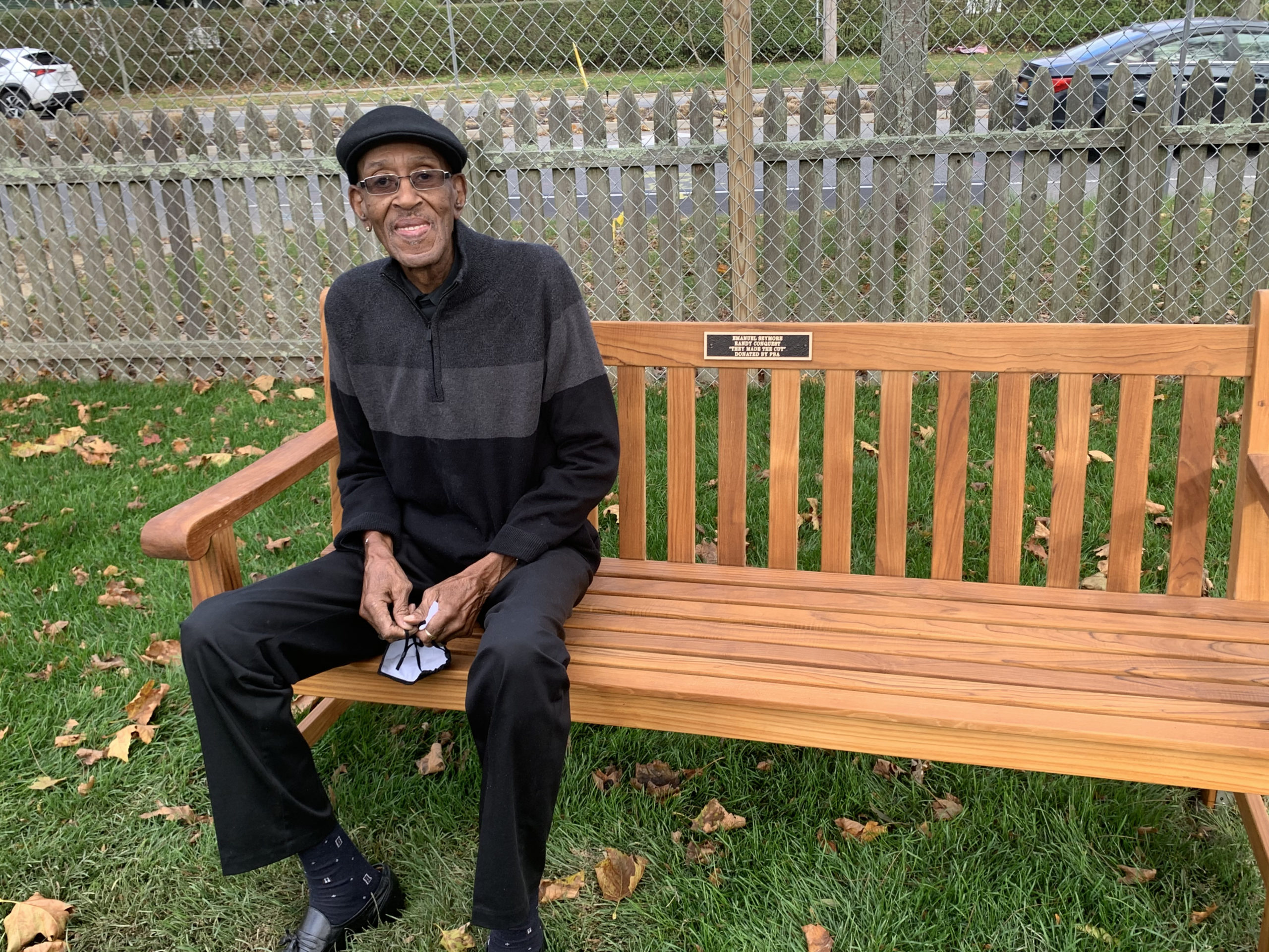 Randy Conquest on a bench dedicated to him and Emanuel Seymore, on the grounds of the Southampton African American Museum.  COURTESY BRENDA SIMMONS