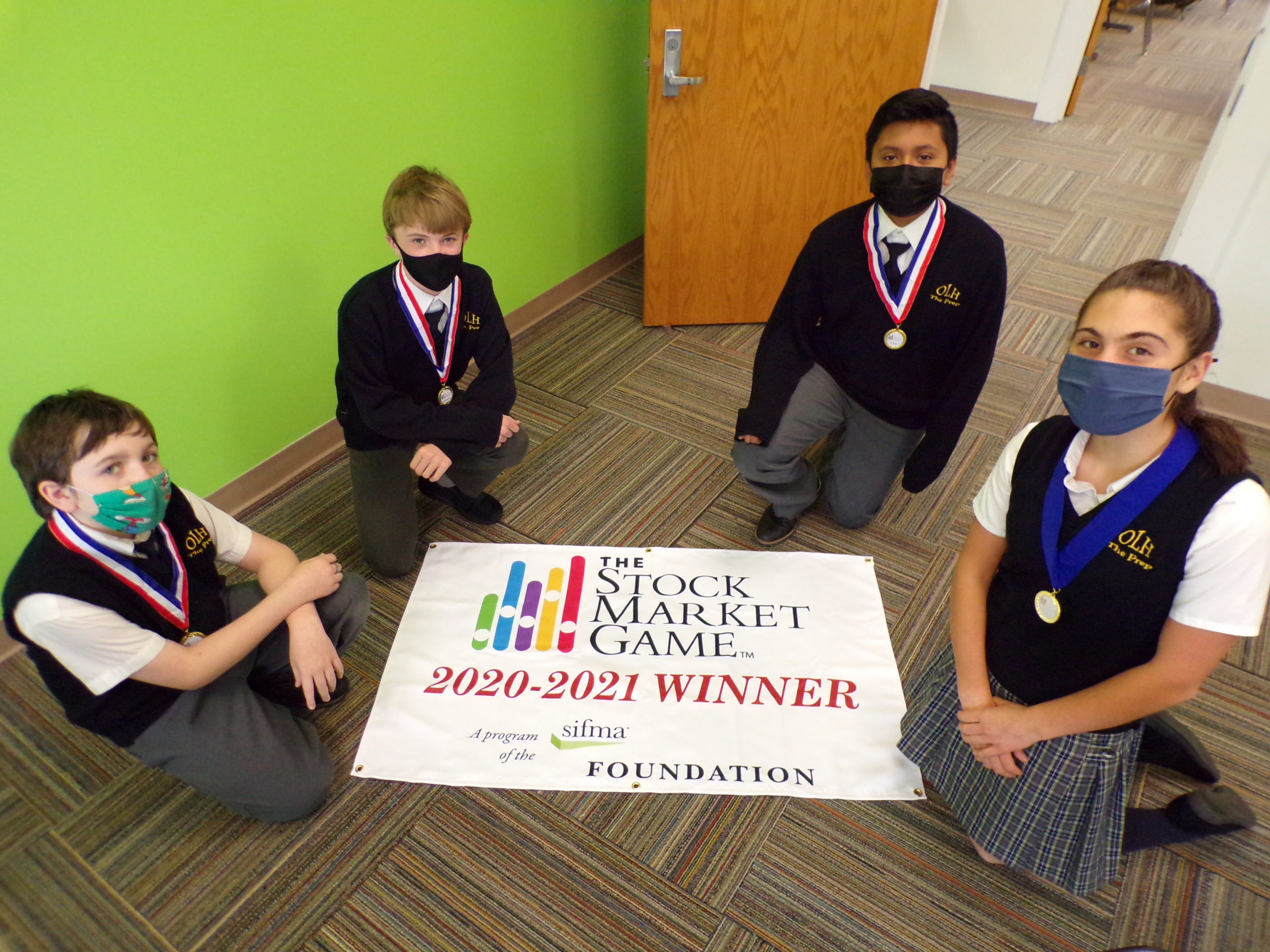 (From left to right) Luke David, George McDonald, Jake Morales and Maxine Boeding. Maxine placed first place in the SIFMA Foundation’s Stock Market Game, with the rest of the students taking a second place award.