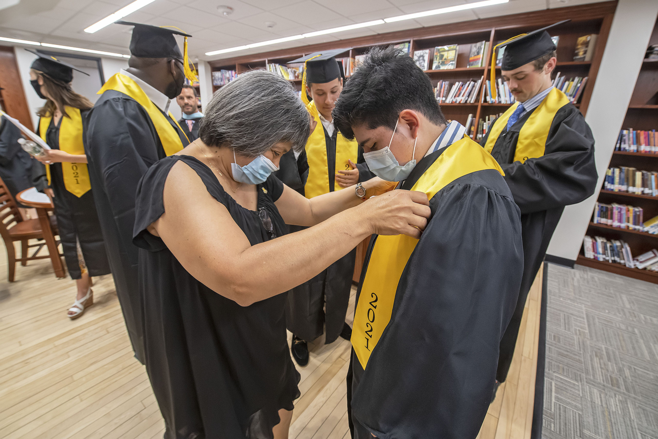 Ninfa Boyd helps Bridgehampton School seniors get dressed in the school's new library prior to the start of their 2021 commencement ceremony on Saturday.    MICHAEL HELLER