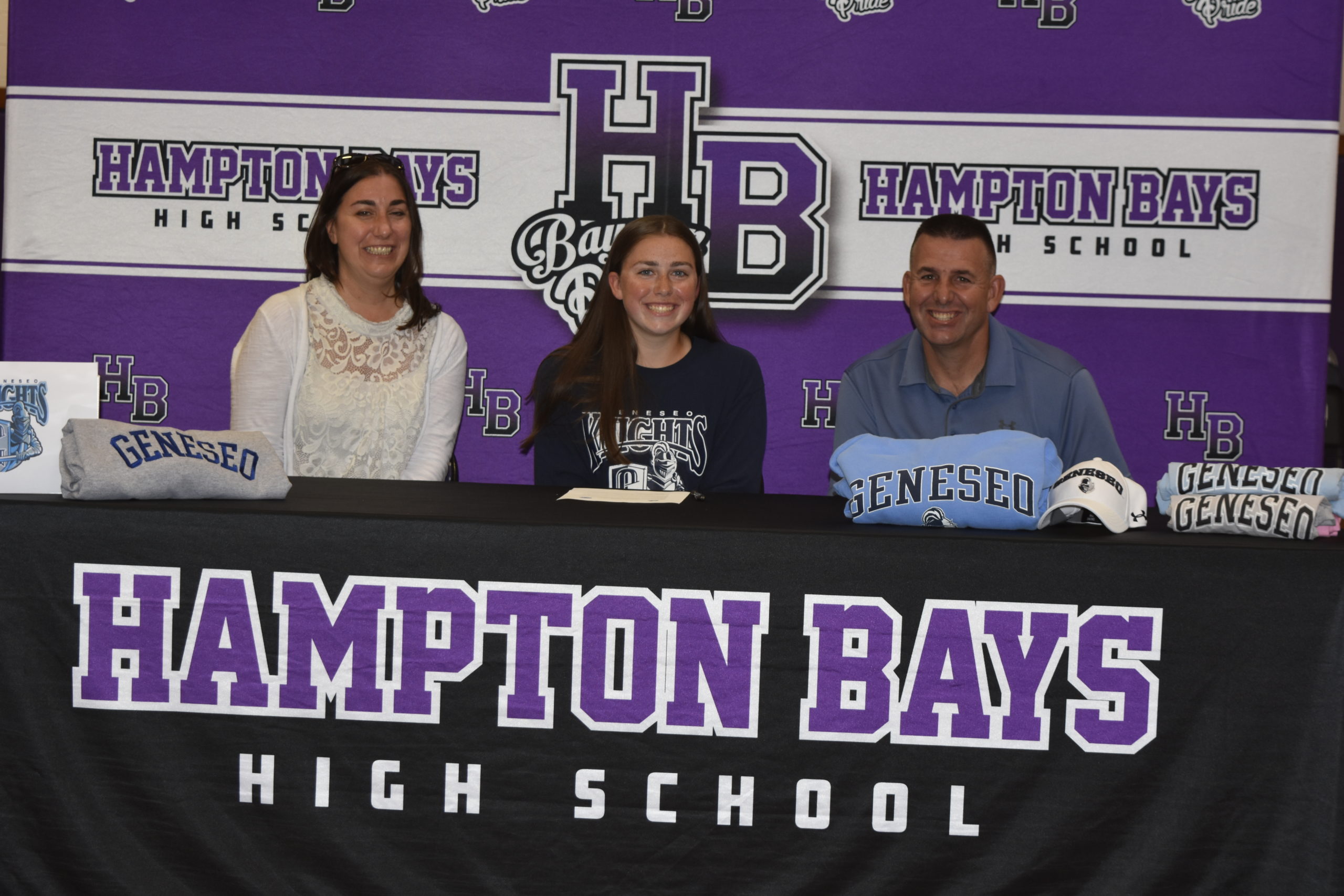 Tara Brochu with her parents, Paul and Tara, signing her letter of intent to play softball at SUNY Geneseo on June 1.
