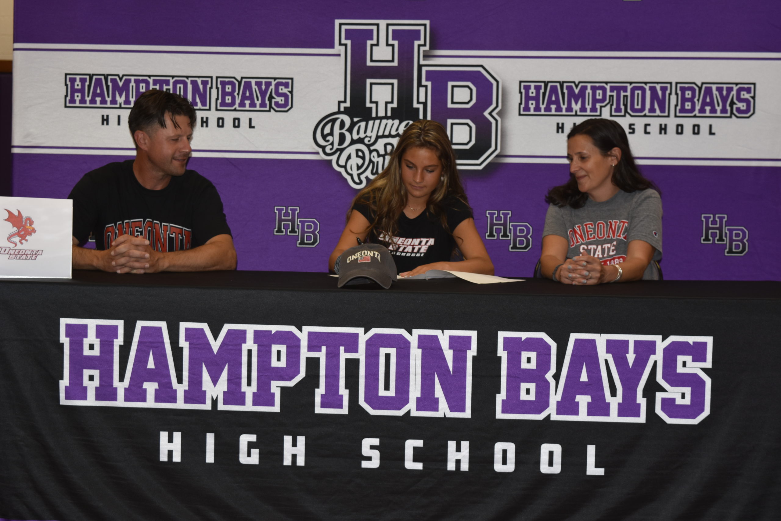 Cassidy Moore, with her parents,  Vinny and Dawn, signing her letter of intent to play lacrosse at SUNY Oneonta.