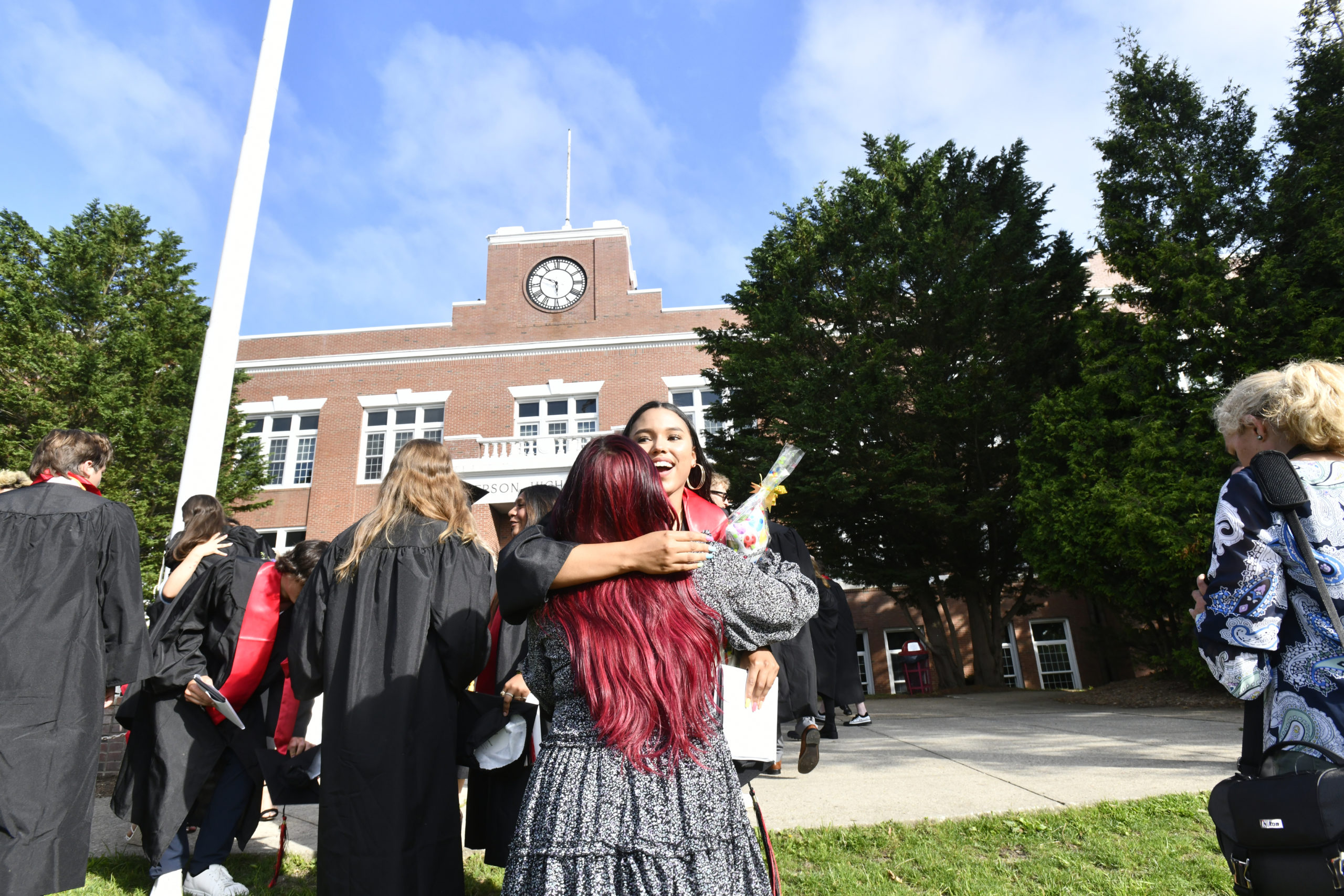 Graduate Juliana Barahona embraces her friend Kemberli Zeas after graduation.  DANA SHAW