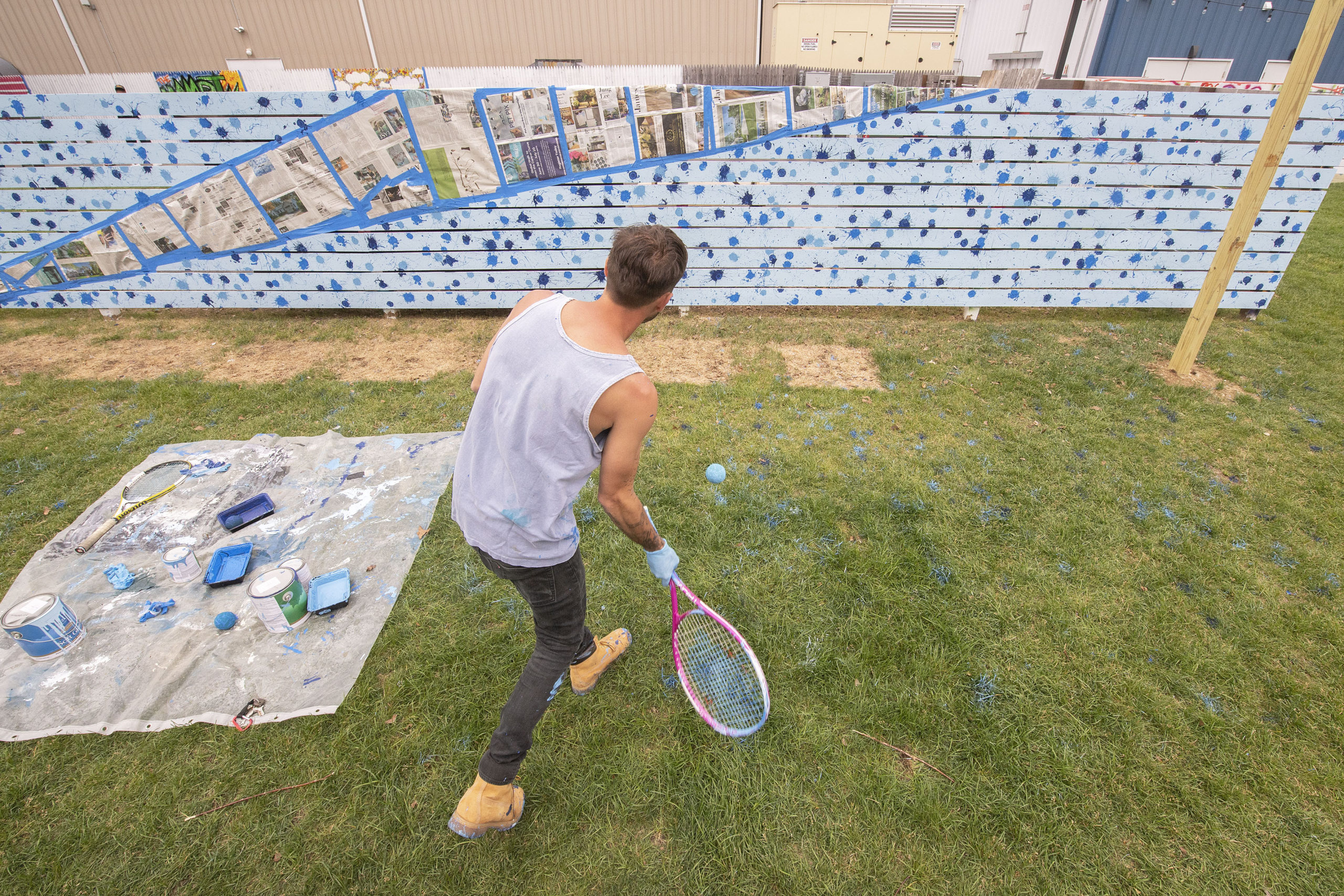 Although technically not part of the competition, Clubhouse employee Matthew Classens uses a tennis racket and a ball soaked in paint to create unique art during the Live Mural and Graffiti Competition at The Clubhouse on Saturday, June 12.