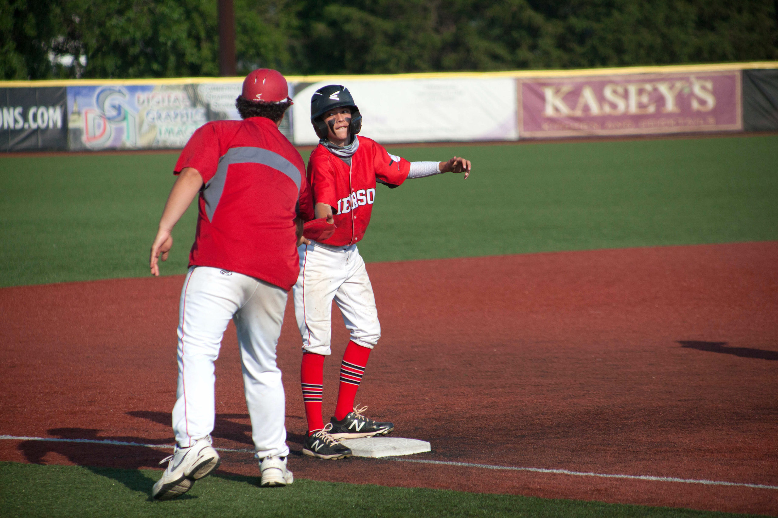 Pierson freshman Dominick Mancino high-fives coach Tyler LaBorne at third base for his offensive efforts.